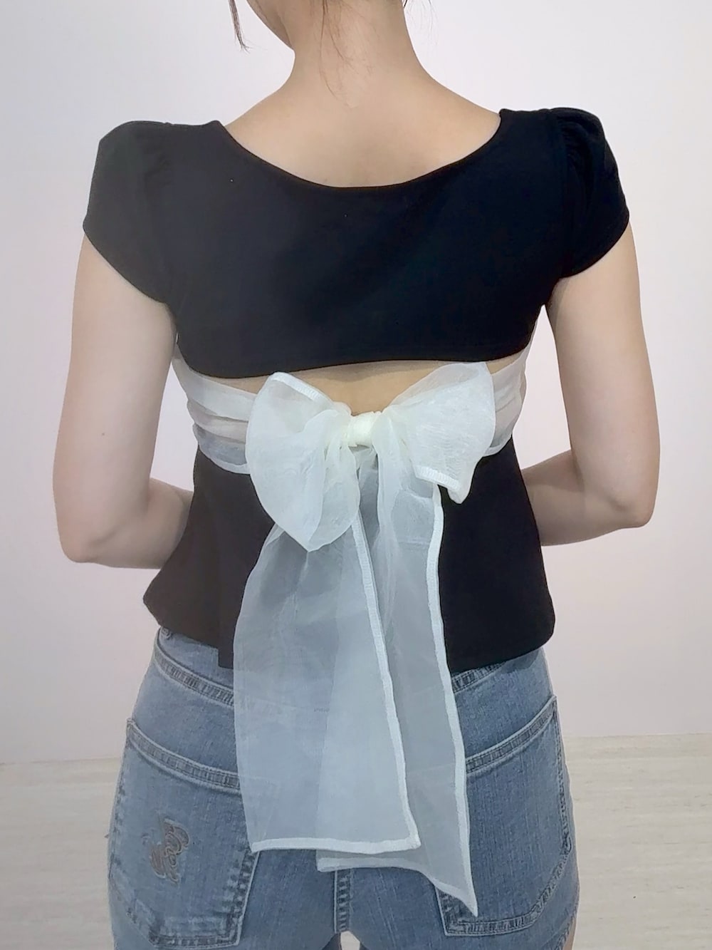 ブラック系のTシャツ/カットソー、ブルー系のデニムパンツ、ブラック系のサンダルを着用したレディースの夏コーディネートの4枚目の写真