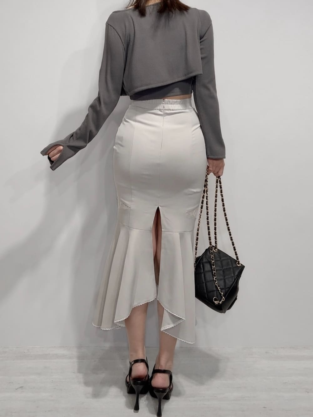 ブラック系のTシャツ/カットソー、ブラック系のスカート、ブラック系のバックパック/リュックを着用したレディースの春コーディネートの3枚目の写真