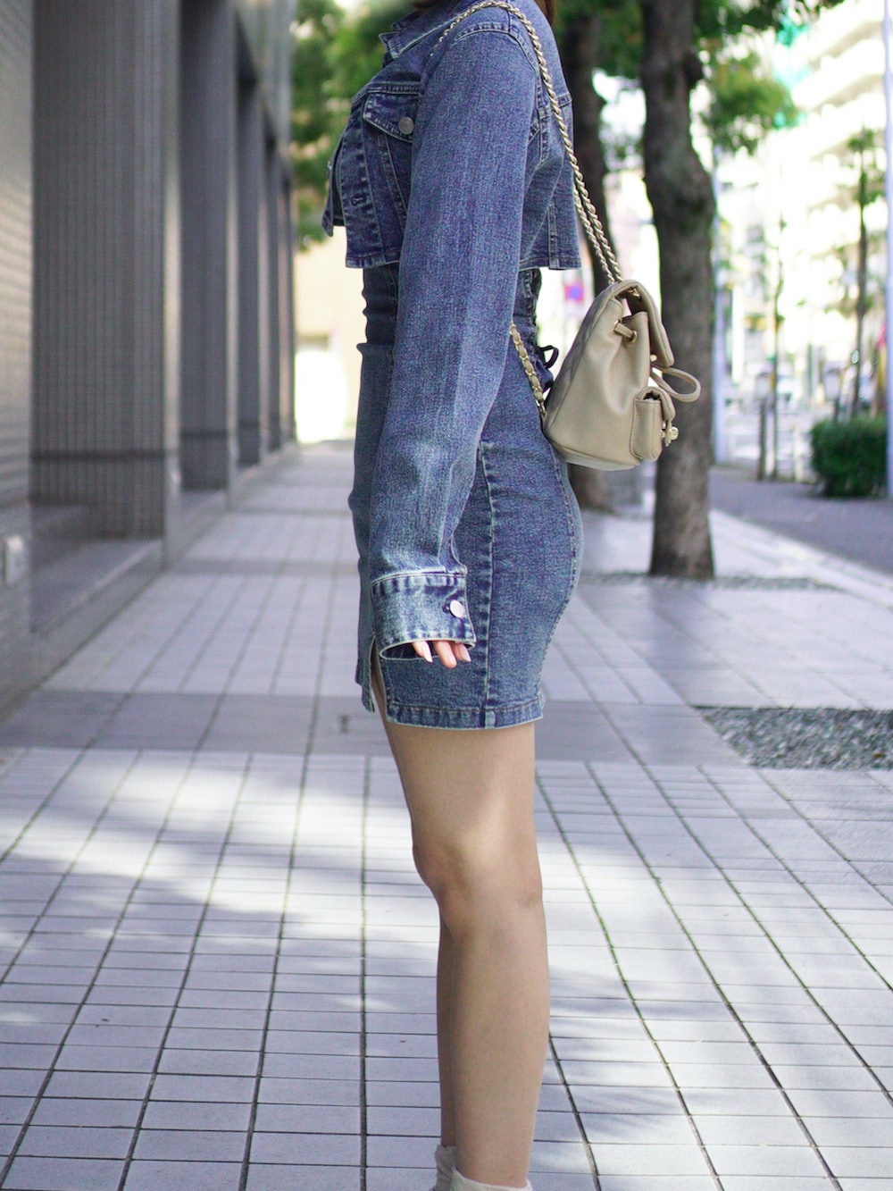 ブルー系のワンピース、ベージュ系のブーツ、ベージュ系のバックパック/リュックを着用したレディースの春コーディネートの5枚目の写真