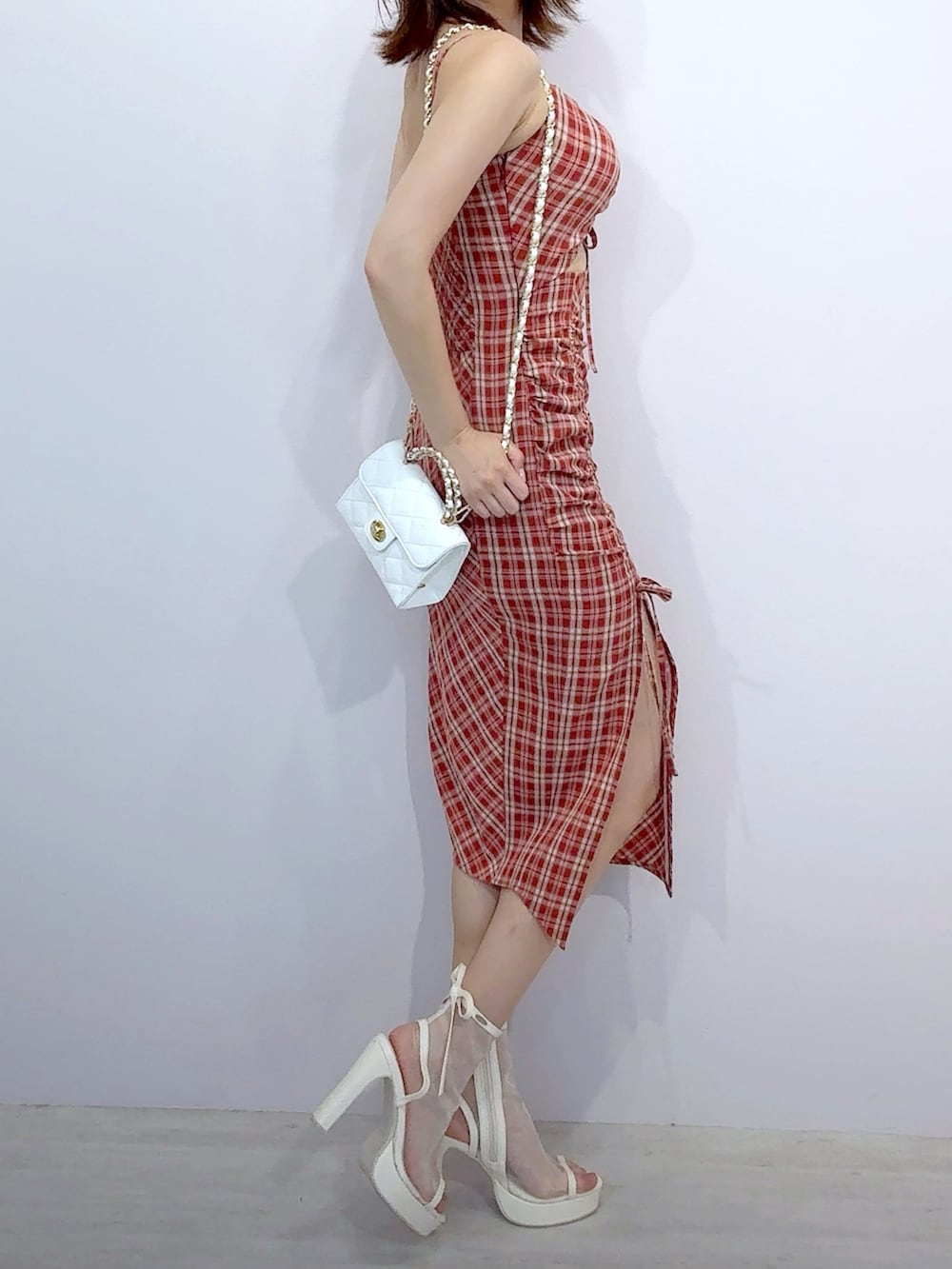 ホワイト系のハンドバッグ、レッド系のワンピース、ホワイト系のサンダルを着用したレディースの夏コーディネートの3枚目の写真