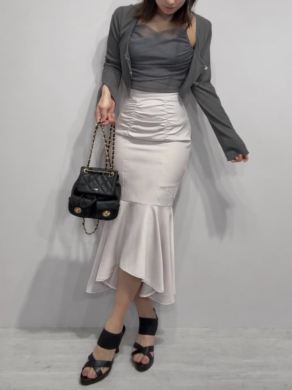 ブラック系のTシャツ/カットソー、ブラック系のスカート、ブラック系のバックパック/リュックを着用したレディースの春コーディネートの2枚目の写真