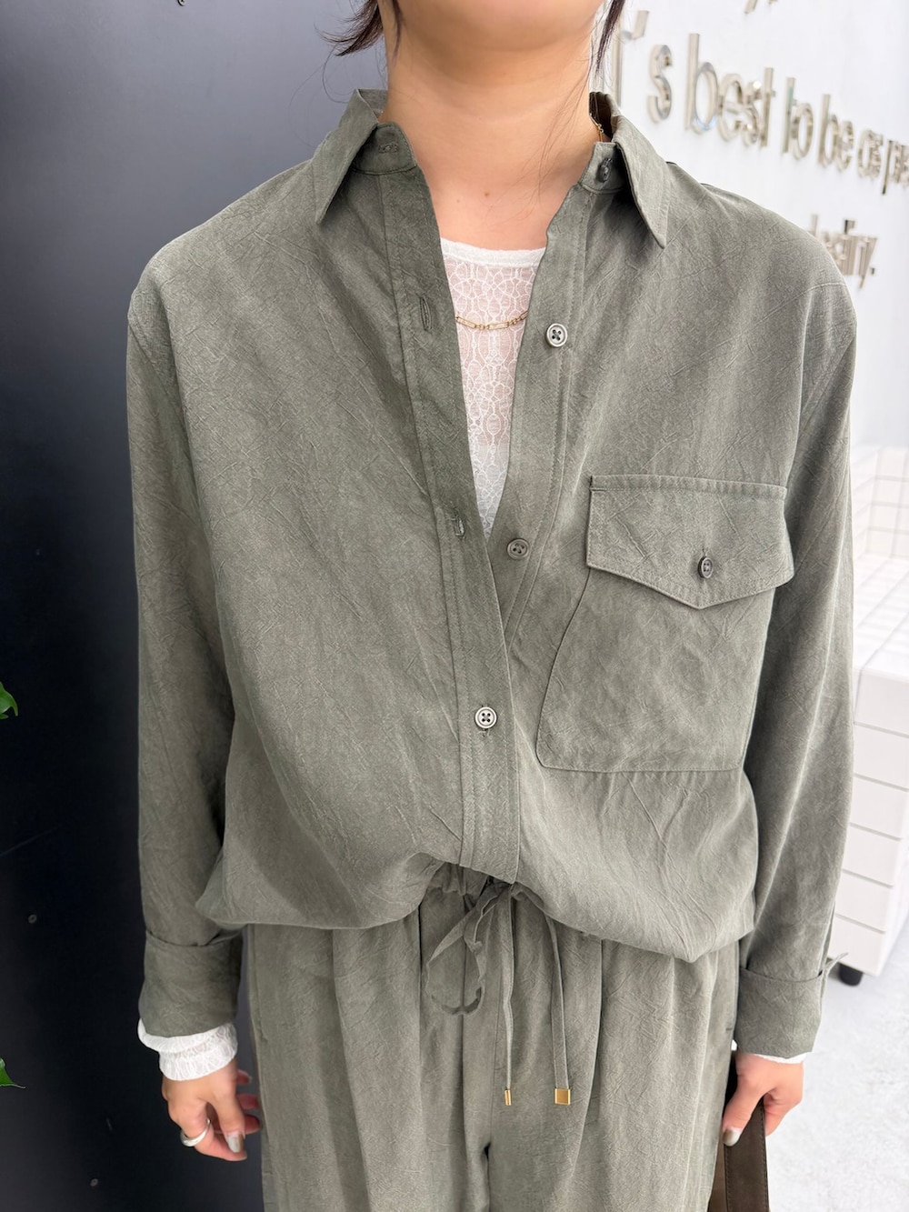 グリーン系のスラックス、グリーン系のシャツ/ブラウス、ホワイト系のTシャツ/カットソーを着用したレディースの秋コーディネートの8枚目の写真