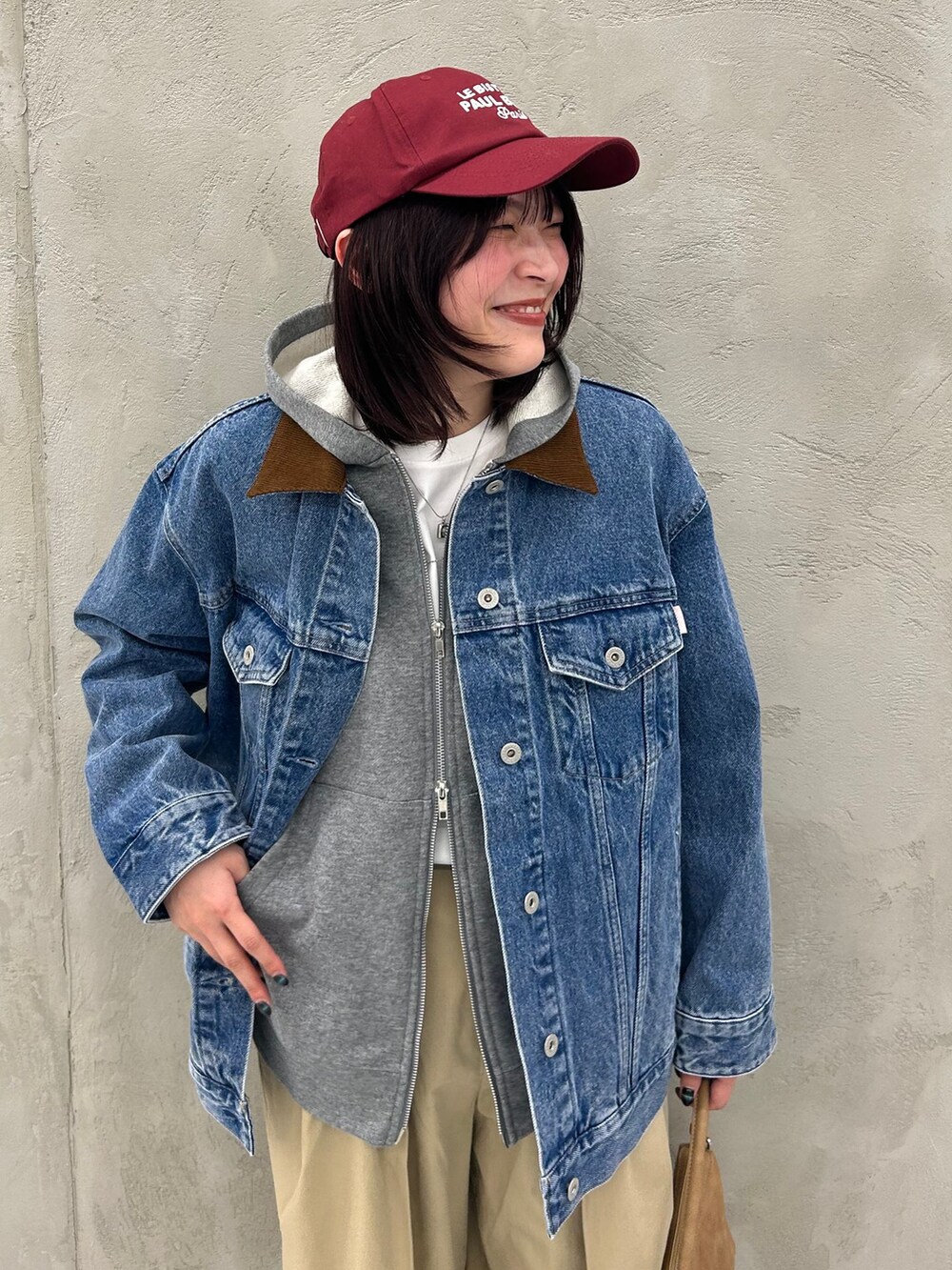 ブルー系のデニムジャケット、ベージュ系のチノパンツ、グレー系のパーカーを着用したレディースの冬コーディネートの9枚目の写真