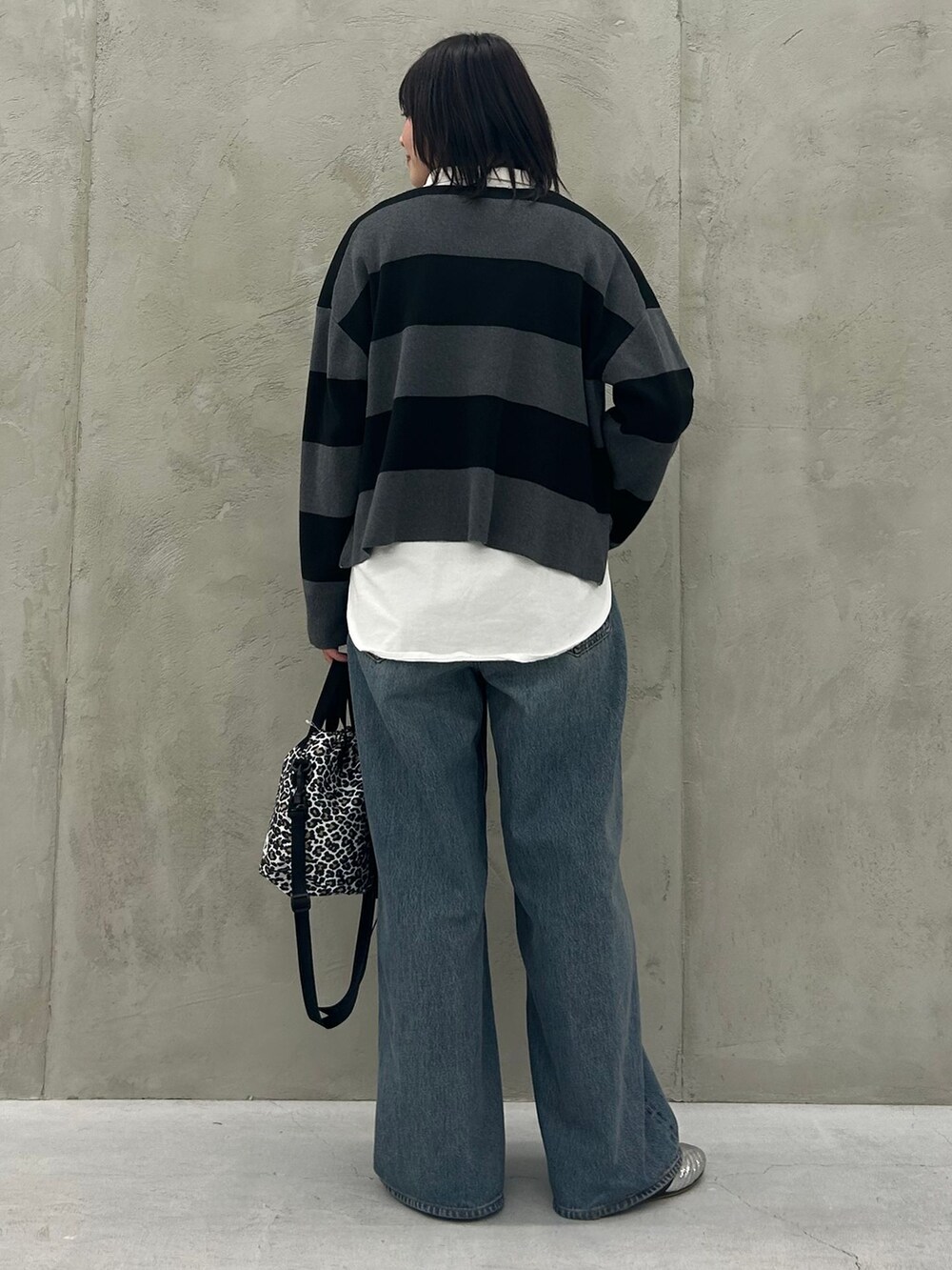 ホワイト系のTシャツ/カットソー、グレー系のニット/セーター、グレー系のショルダーバッグを着用したレディースの冬コーディネートの5枚目の写真