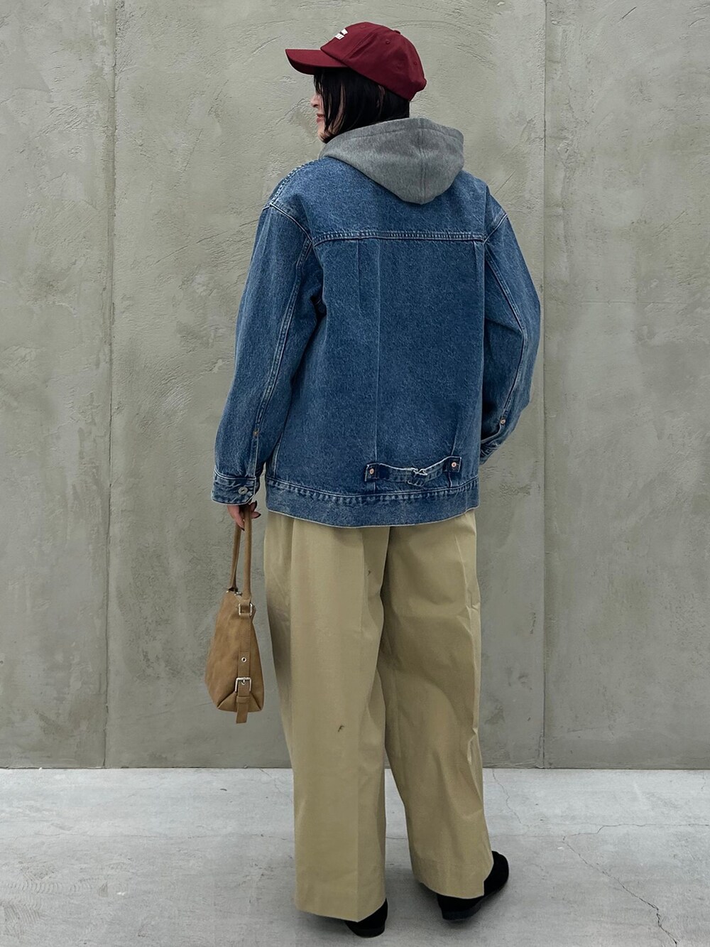 ブルー系のデニムジャケット、ベージュ系のチノパンツ、グレー系のパーカーを着用したレディースの冬コーディネートの5枚目の写真