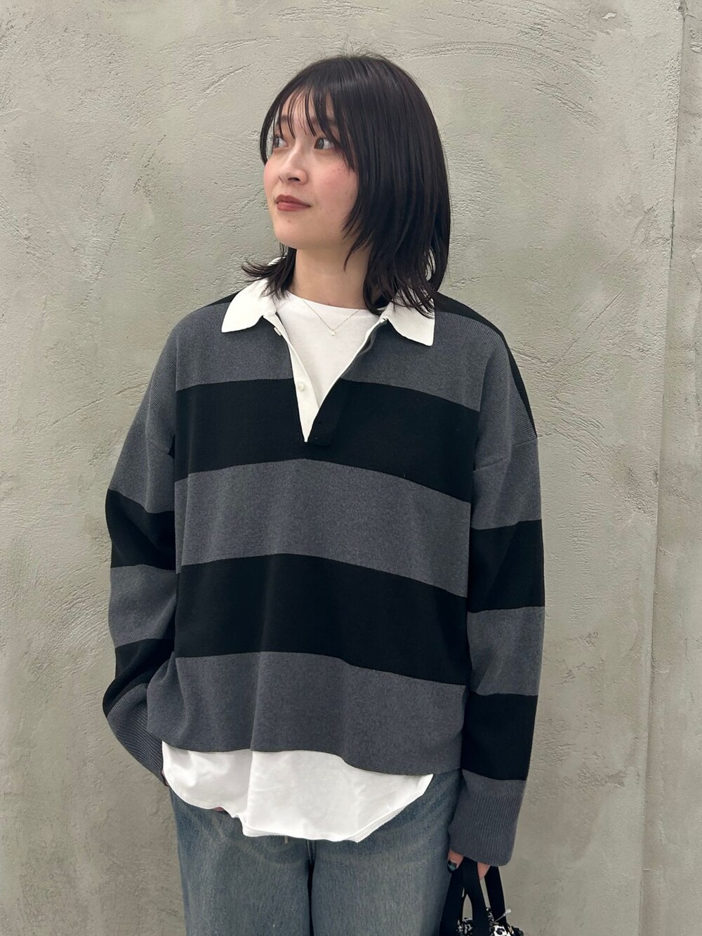 ホワイト系のTシャツ/カットソー、グレー系のニット/セーター、グレー系のショルダーバッグを着用したレディースの冬コーディネートの8枚目の写真