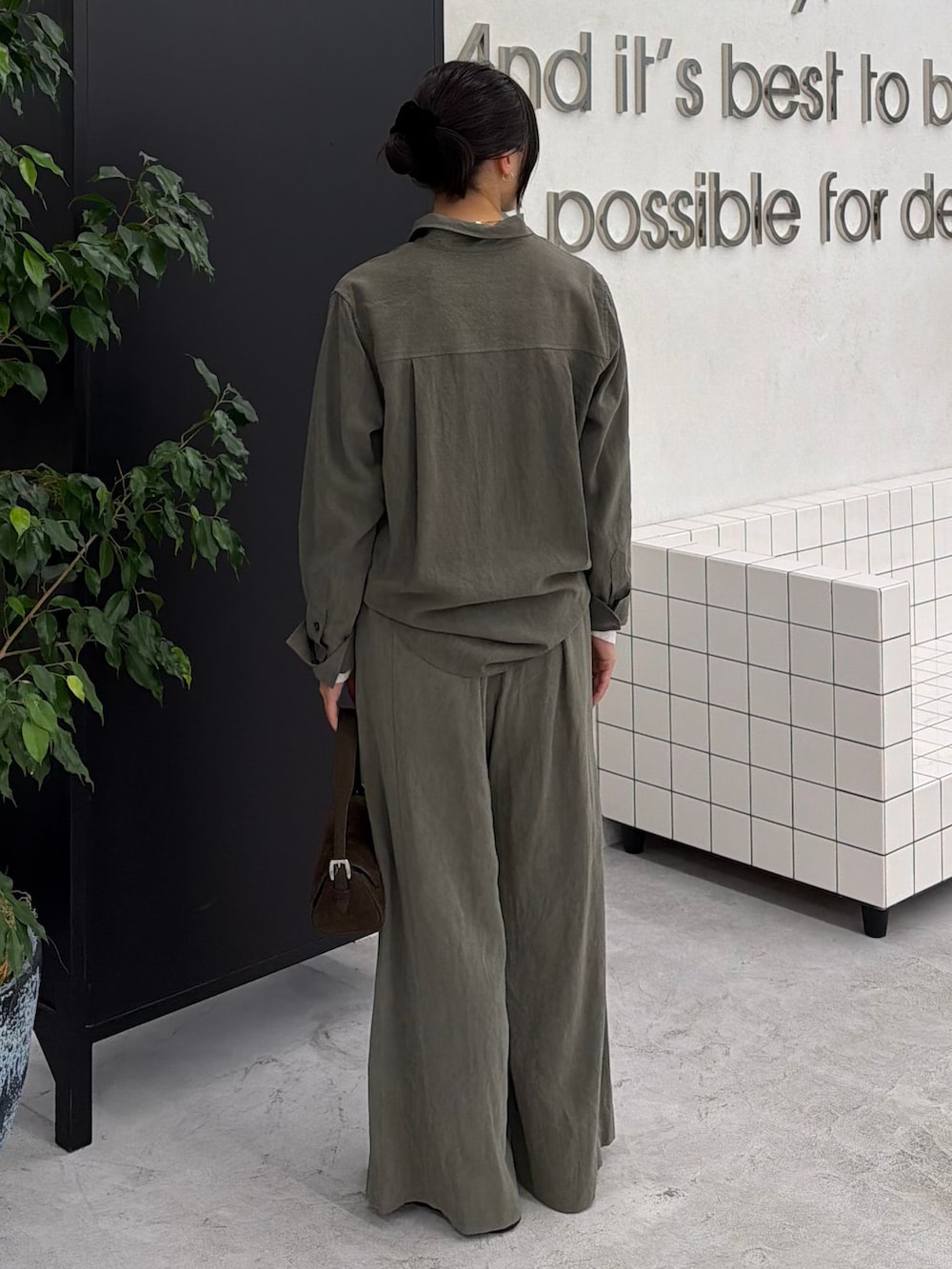 グリーン系のスラックス、グリーン系のシャツ/ブラウス、ホワイト系のTシャツ/カットソーを着用したレディースの秋コーディネートの4枚目の写真