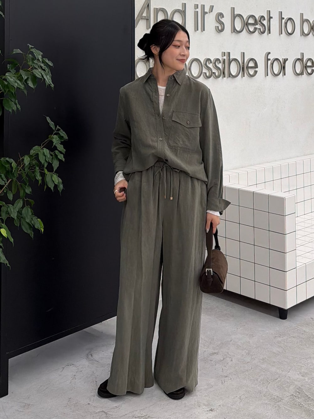 グリーン系のスラックス、グリーン系のシャツ/ブラウス、ホワイト系のTシャツ/カットソーを着用したレディースの秋コーディネートの2枚目の写真