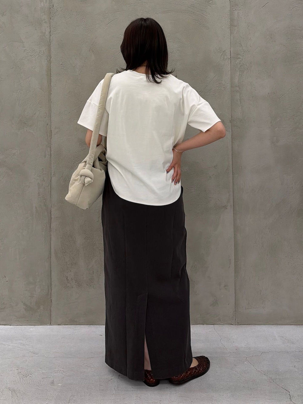ブラック系のスカート、ホワイト系のTシャツ/カットソー、ベージュ系のショルダーバッグを着用したレディースの春コーディネートの5枚目の写真