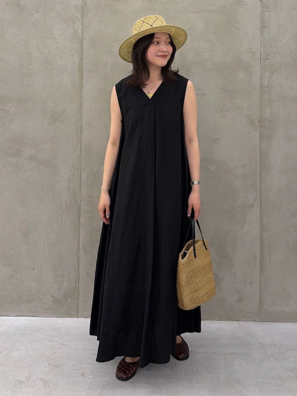 ブラック系のワンピース、ブラック系のワンピース、イエロー系のTシャツ/カットソーを着用したレディースの春コーディネートの2枚目の写真