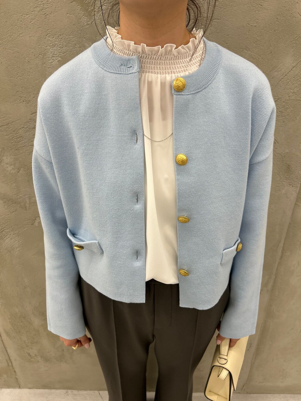 グレー系のスラックス、ホワイト系のシャツ/ブラウス、ブルー系のカーディガン/ボレロを着用したレディースの冬コーディネートの8枚目の写真