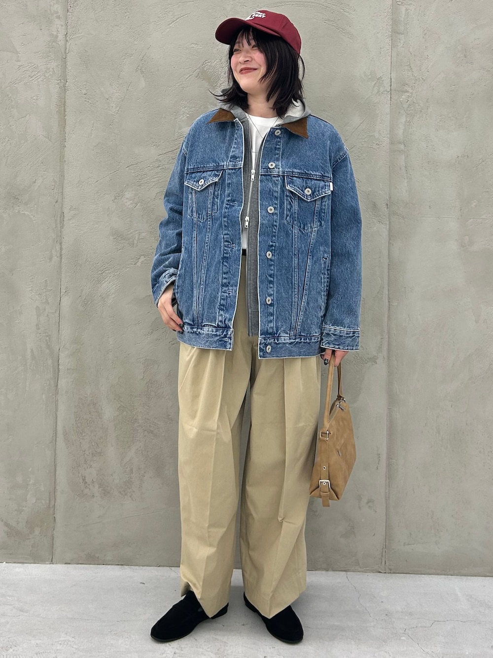ブルー系のデニムジャケット、ベージュ系のチノパンツ、グレー系のパーカーを着用したレディースの冬コーディネートの3枚目の写真