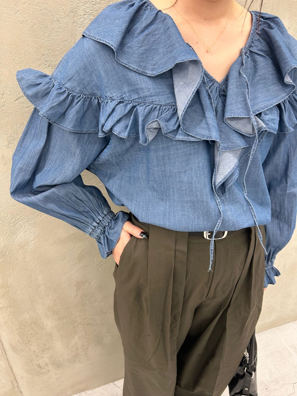 グリーン系のチノパンツ、ブルー系のシャツ/ブラウス、ブラック系のショルダーバッグを着用したレディースの冬コーディネートの10枚目の写真