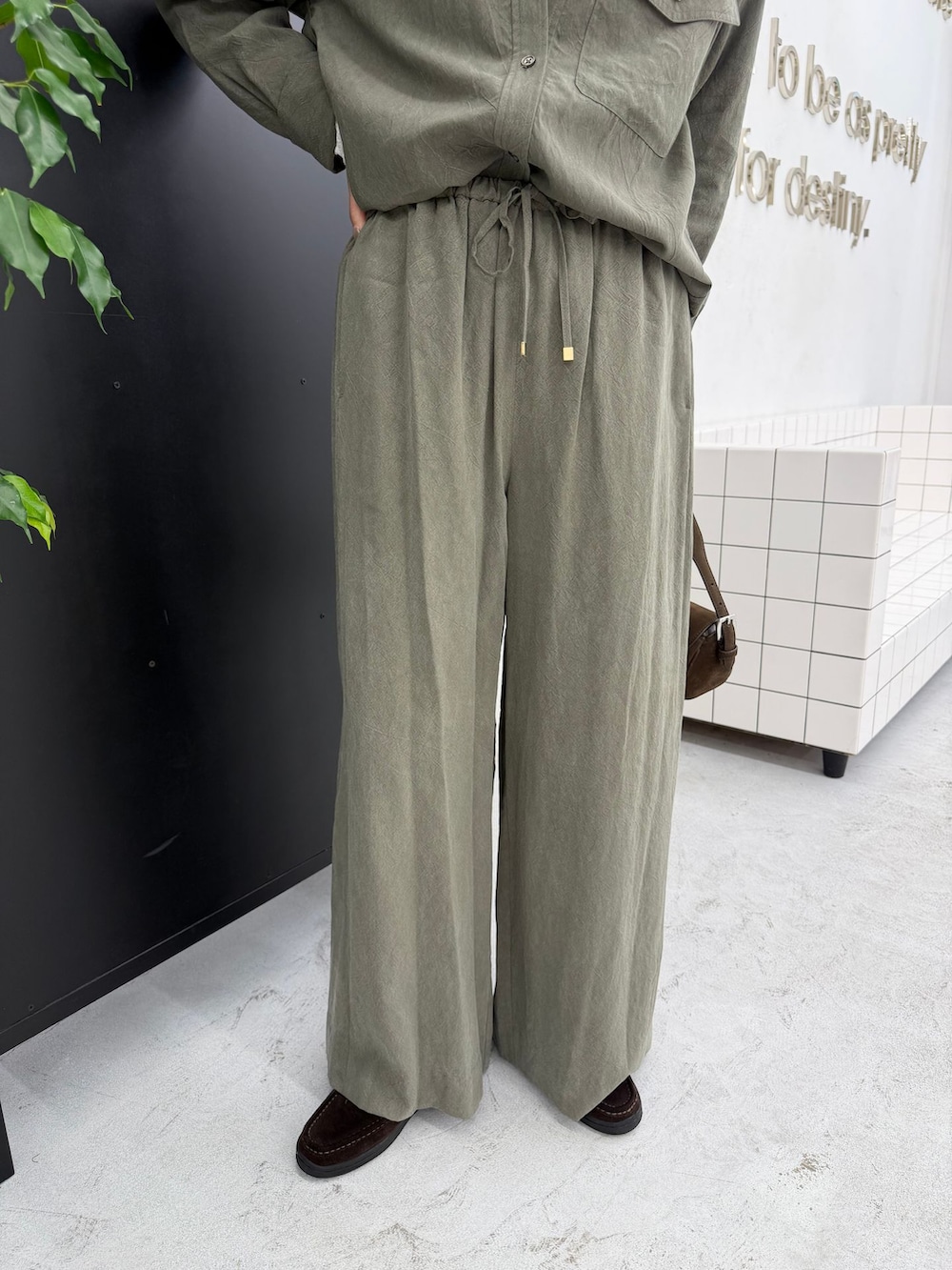 グリーン系のスラックス、グリーン系のシャツ/ブラウス、ホワイト系のTシャツ/カットソーを着用したレディースの秋コーディネートの10枚目の写真