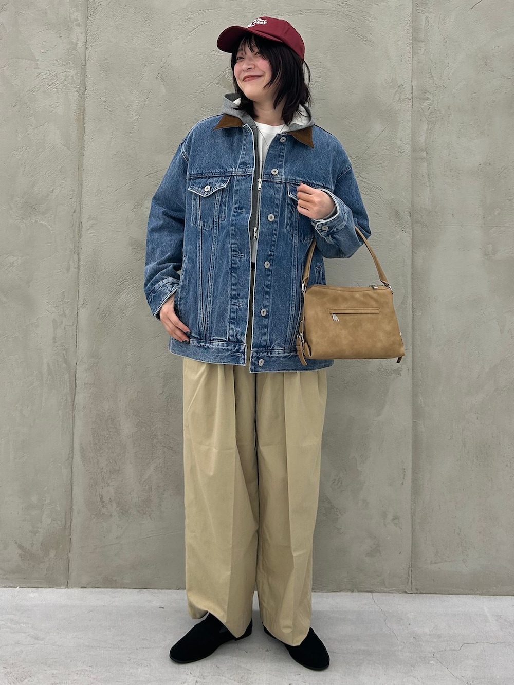 ブルー系のデニムジャケット、ベージュ系のチノパンツ、グレー系のパーカーを着用したレディースの冬コーディネートの2枚目の写真