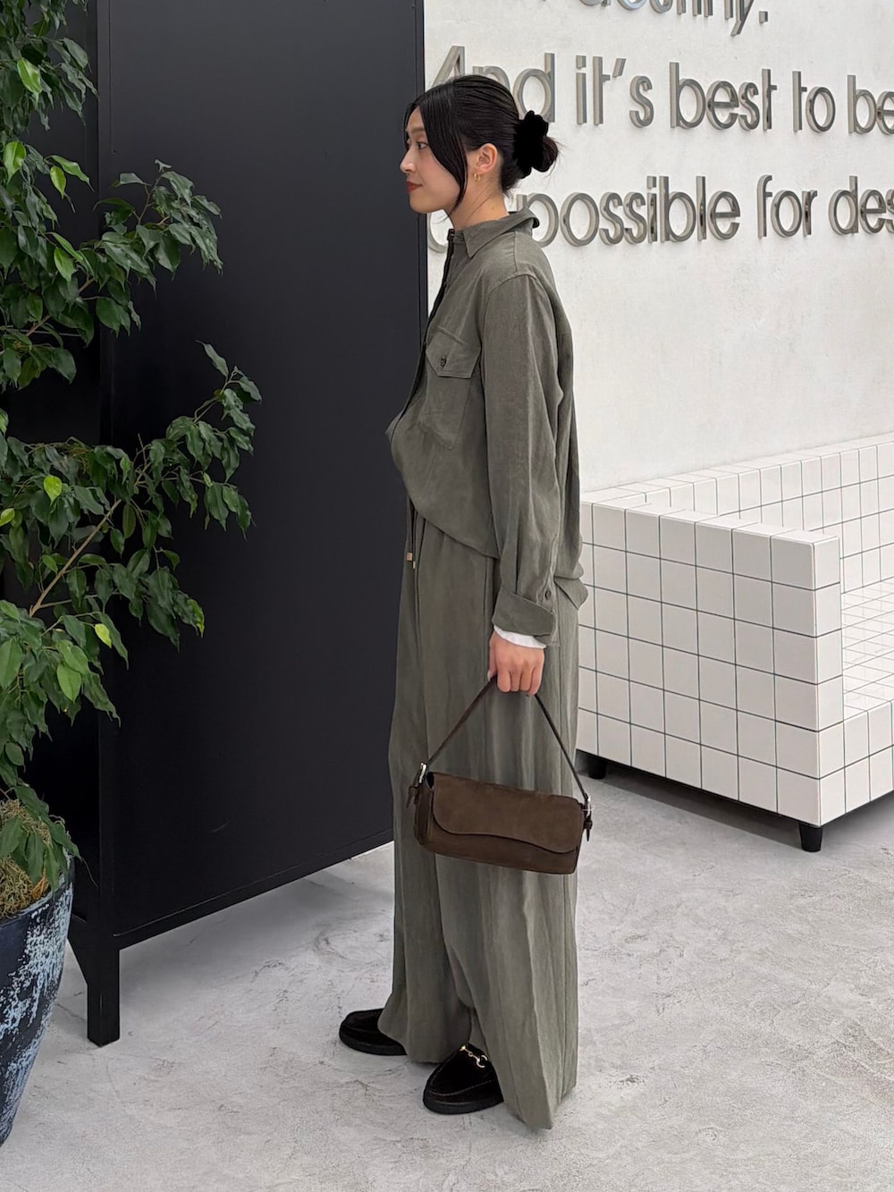 グリーン系のスラックス、グリーン系のシャツ/ブラウス、ホワイト系のTシャツ/カットソーを着用したレディースの秋コーディネートの5枚目の写真