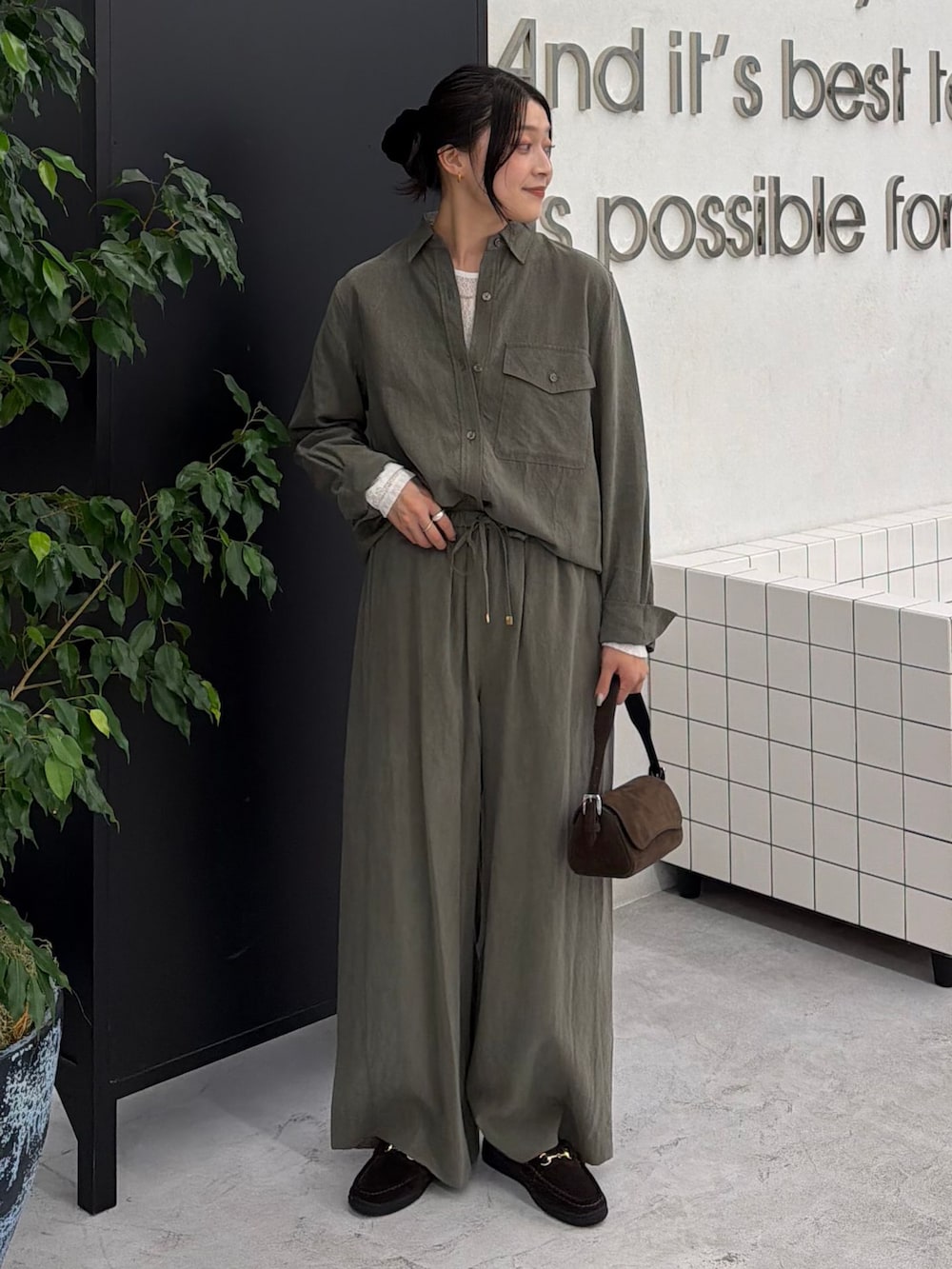 グリーン系のスラックス、グリーン系のシャツ/ブラウス、ホワイト系のTシャツ/カットソーを着用したレディースの秋コーディネートの7枚目の写真