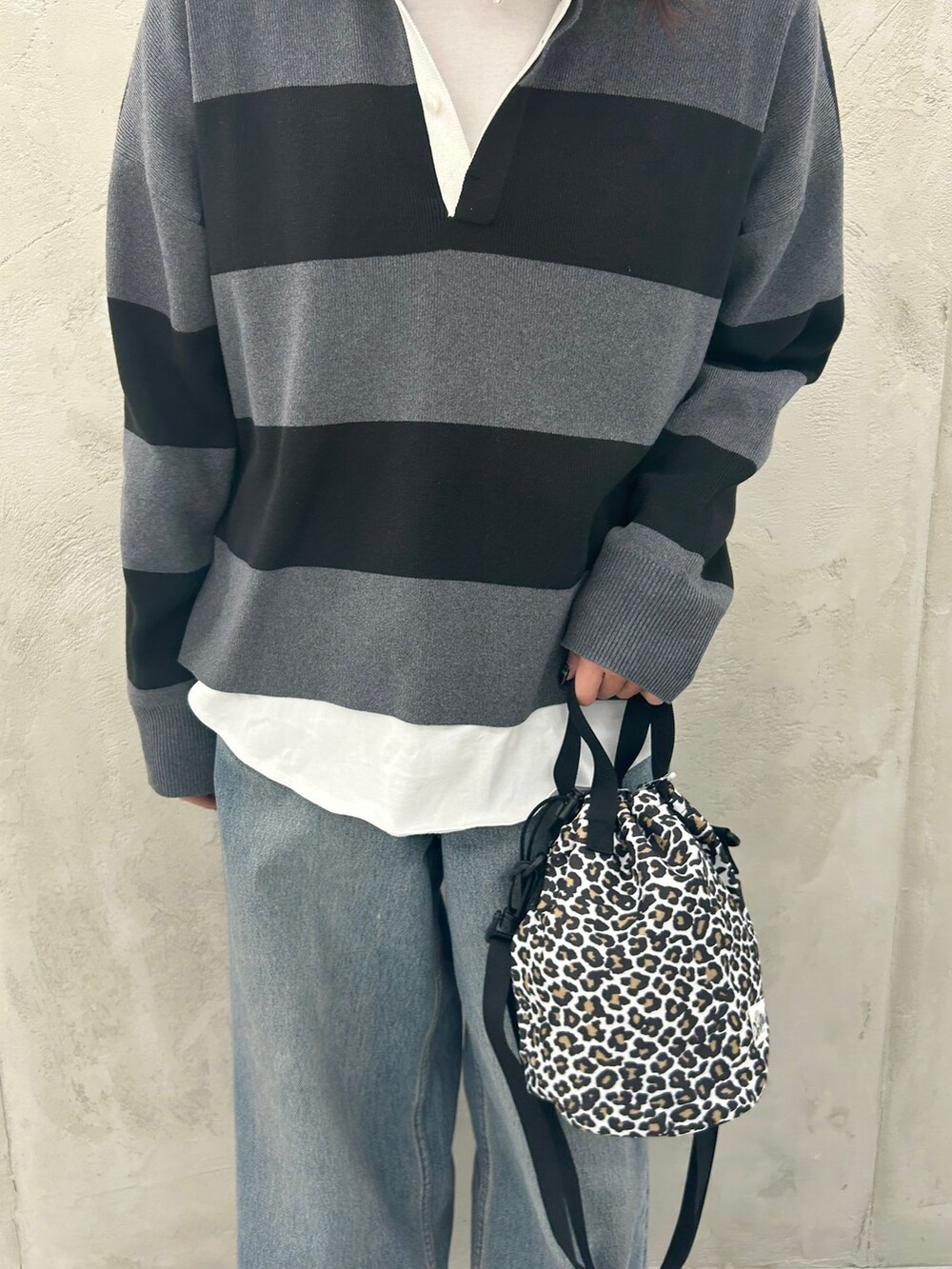 ホワイト系のTシャツ/カットソー、グレー系のニット/セーター、グレー系のショルダーバッグを着用したレディースの冬コーディネートの9枚目の写真