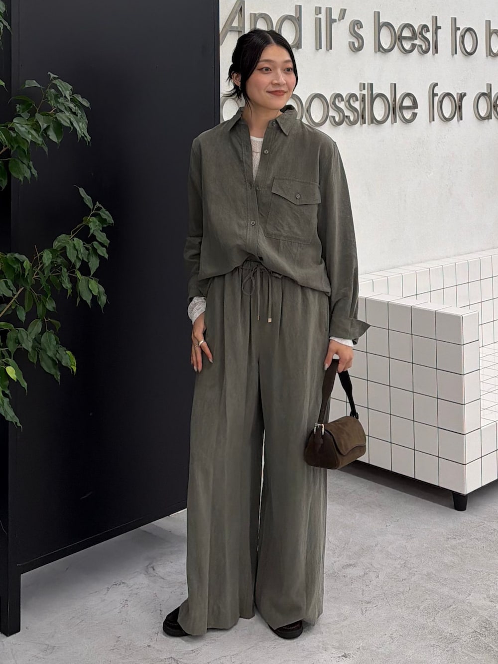 グリーン系のスラックス、グリーン系のシャツ/ブラウス、ホワイト系のTシャツ/カットソーを着用したレディースの秋コーディネートの6枚目の写真