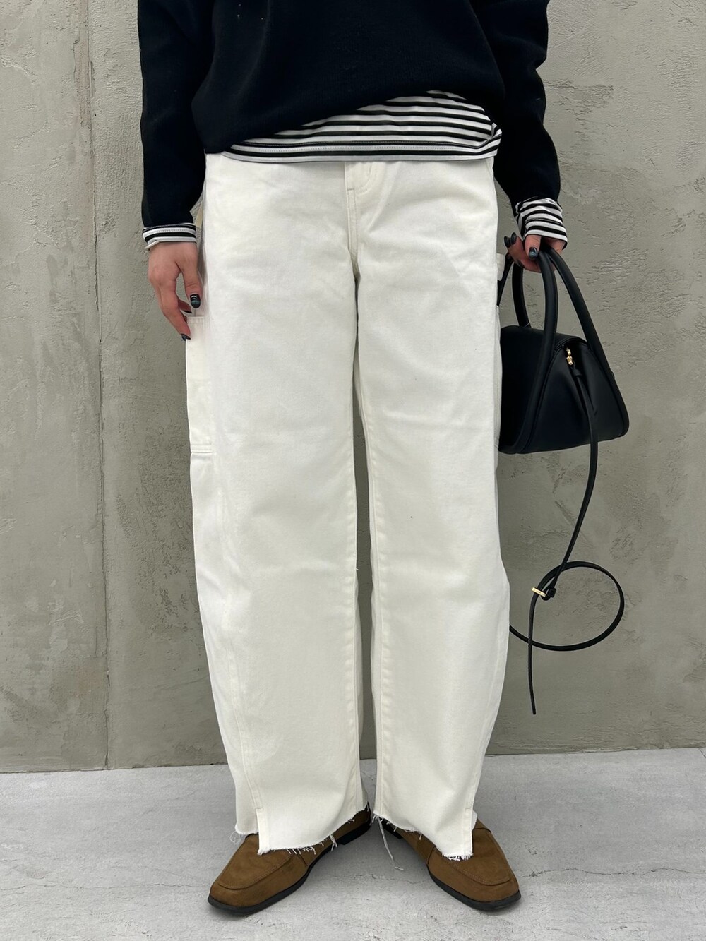 ホワイト系のデニムパンツ、ブラック系のTシャツ/カットソー、ブラック系のニット/セーターを着用したレディースの冬コーディネートの9枚目の写真