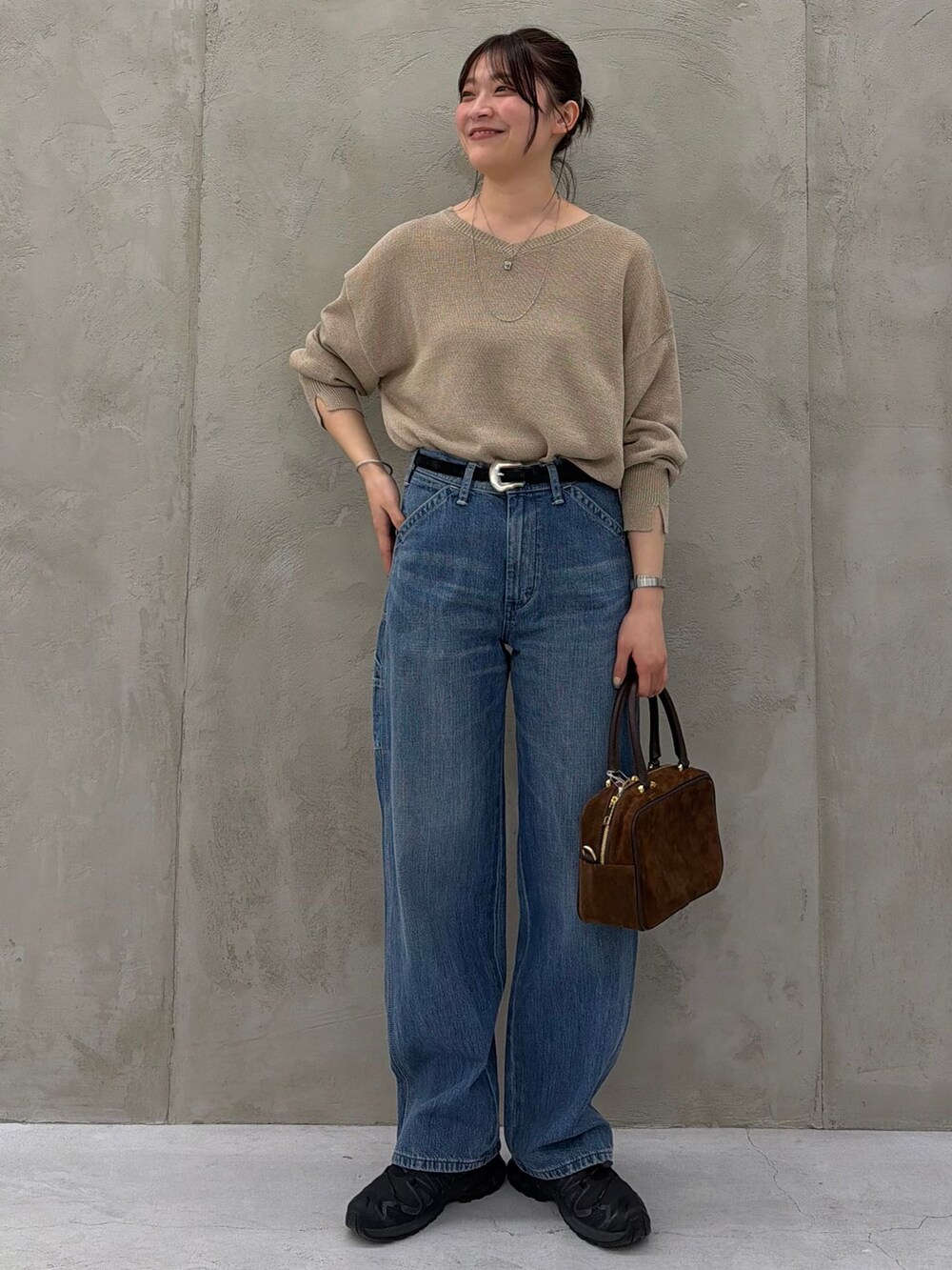 ブルー系のデニムパンツ、ベージュ系のニット/セーター、ブラウン系のショルダーバッグを着用したレディースの春コーディネートの8枚目の写真