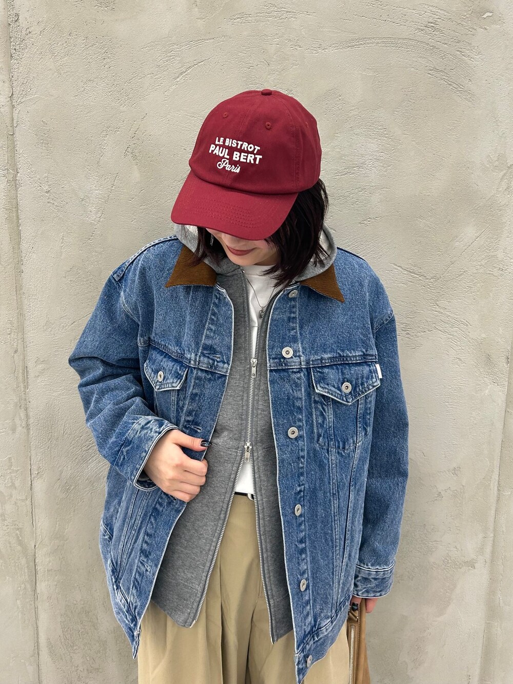 ブルー系のデニムジャケット、ベージュ系のチノパンツ、グレー系のパーカーを着用したレディースの冬コーディネートの10枚目の写真