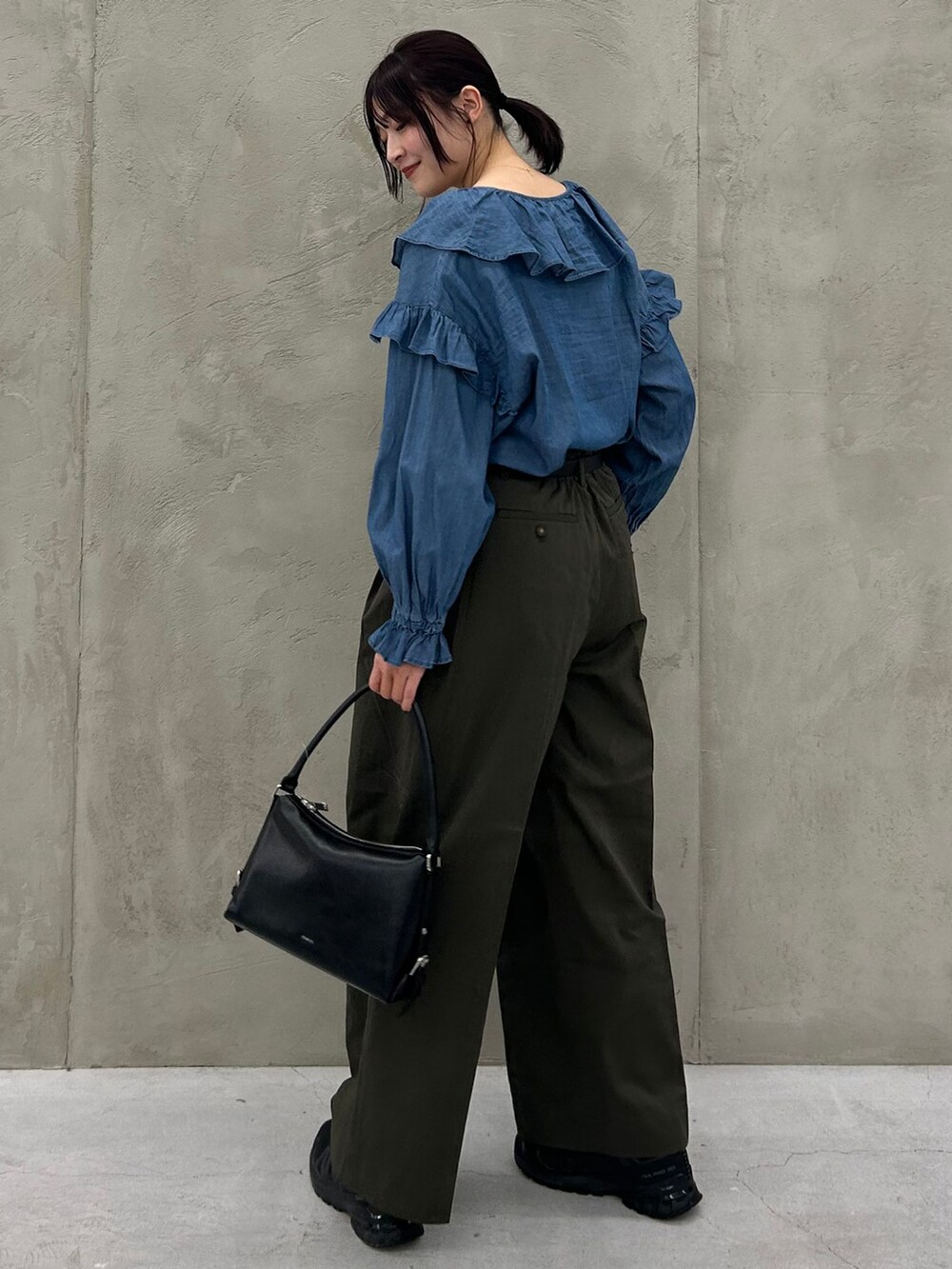 グリーン系のチノパンツ、ブルー系のシャツ/ブラウス、ブラック系のショルダーバッグを着用したレディースの冬コーディネートの3枚目の写真