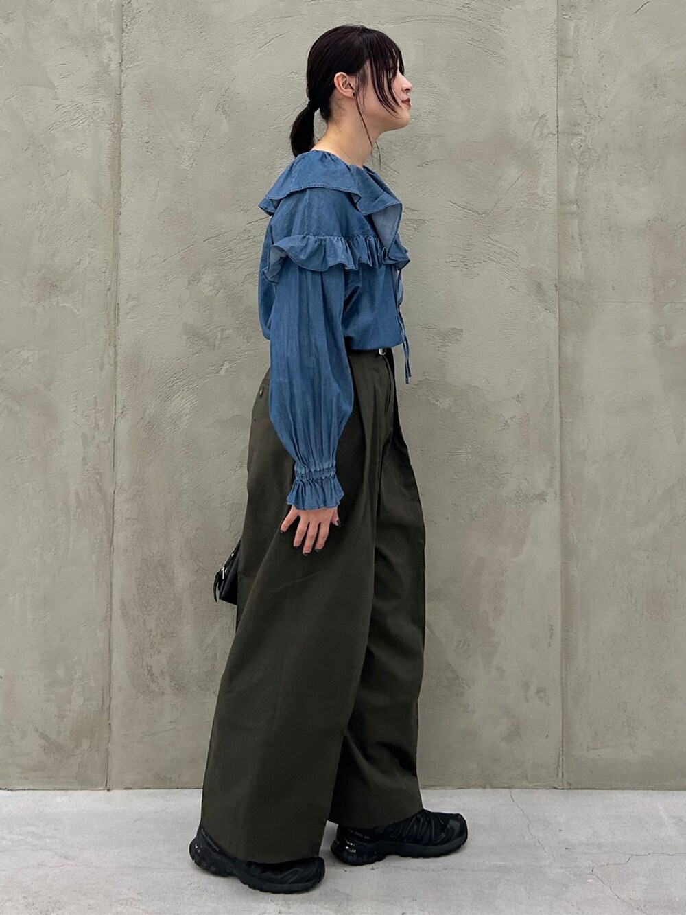 グリーン系のチノパンツ、ブルー系のシャツ/ブラウス、ブラック系のショルダーバッグを着用したレディースの冬コーディネートの6枚目の写真