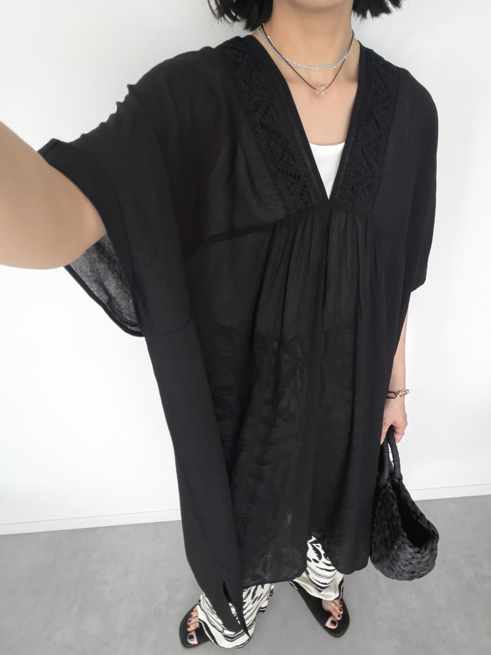 ブラック系のかごバッグ、その他のワンピース、ホワイト系のパンツを着用したレディースの夏コーディネートの4枚目の写真