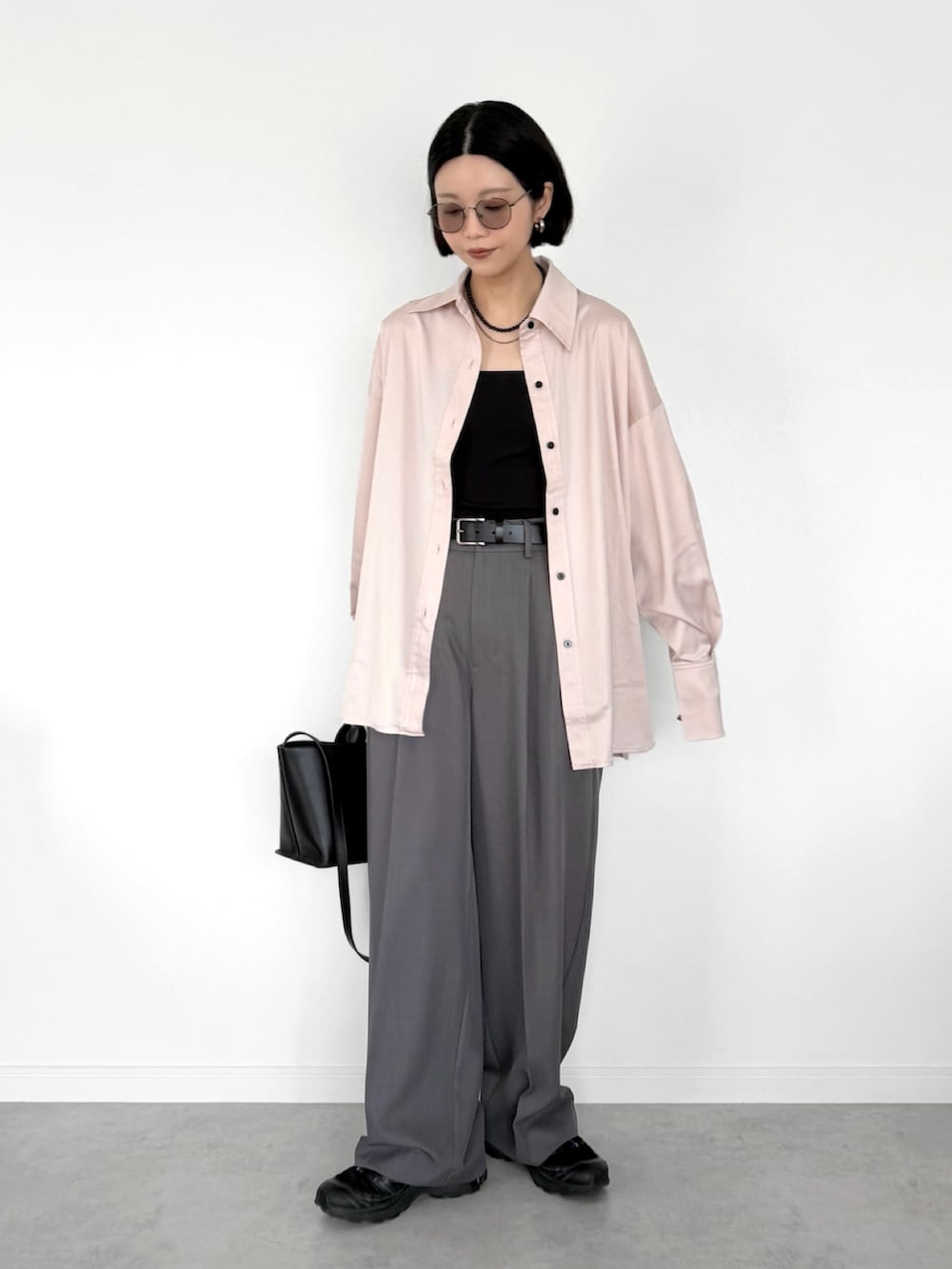 ピンク系のシャツ/ブラウス、グレー系のスラックス、ブラック系のスニーカーを着用したレディースの春コーディネートの2枚目の写真