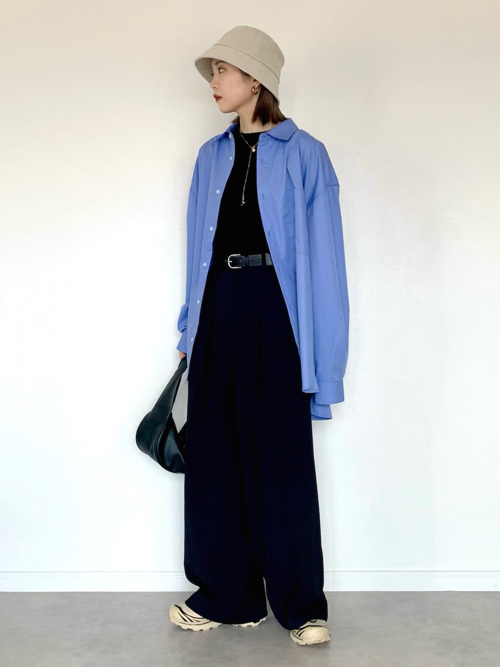 ブルー系のシャツ/ブラウス、ブラック系のその他パンツ、ブラック系のハンドバッグを着用したレディースの春コーディネートの2枚目の写真