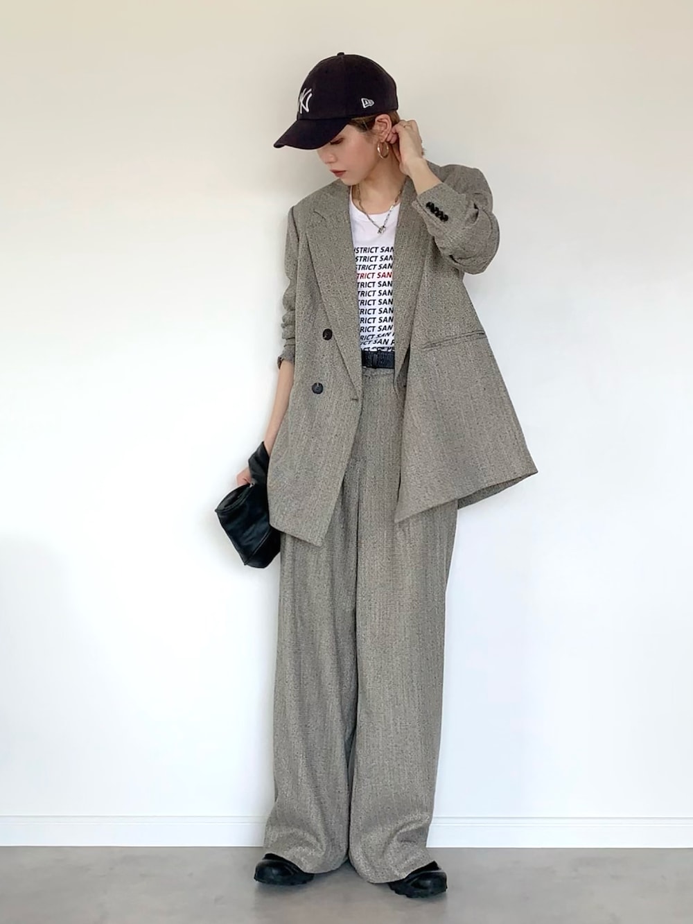 ベージュ系のテーラードジャケット、ベージュ系のパンツ、ブラック系のスニーカーを着用したレディースの秋コーディネートの2枚目の写真