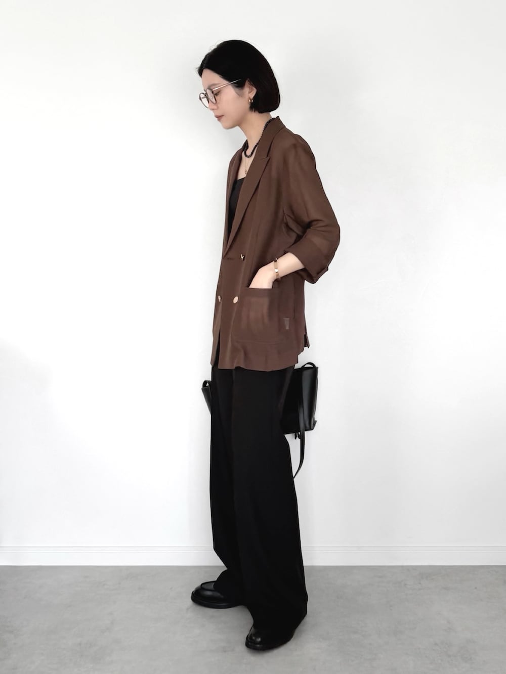 ブラウン系のテーラードジャケット、ブラック系のスラックス、ブラック系のトートバッグを着用したレディースの春コーディネートの3枚目の写真