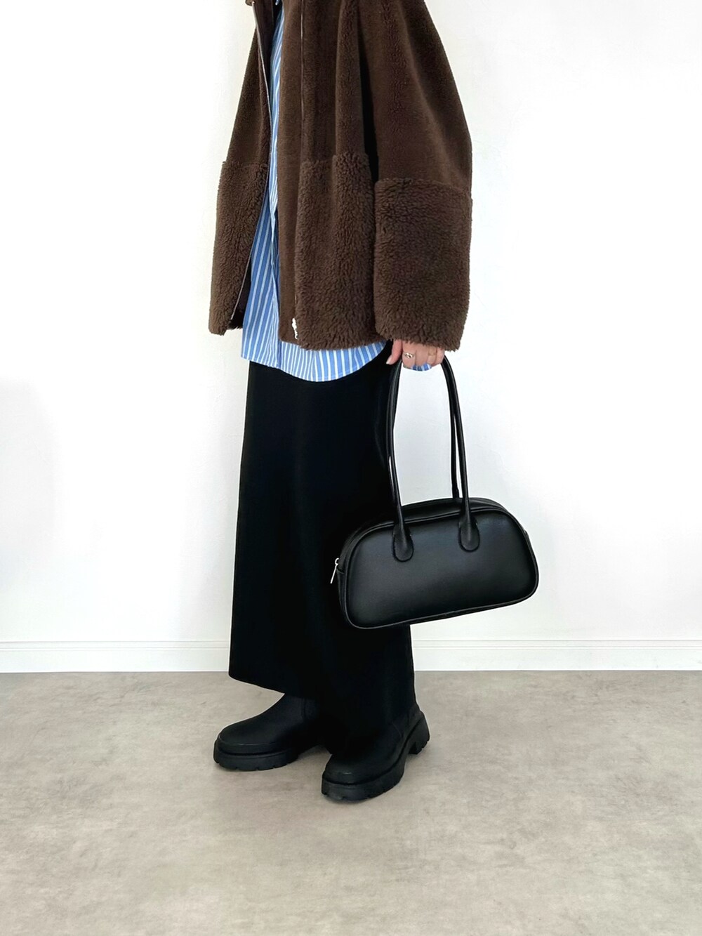 ブラック系のバッグ、ブルー系のシャツ/ブラウス、ブラック系のスカートを着用したレディースの冬コーディネートの2枚目の写真