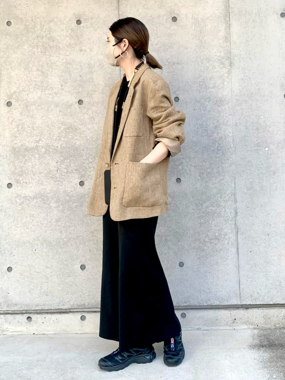 ブラック系のボディバッグ/ウエストポーチ、ベージュ系のテーラードジャケット、ブラック系のスカートを着用したレディースの春コーディネートの2枚目の写真