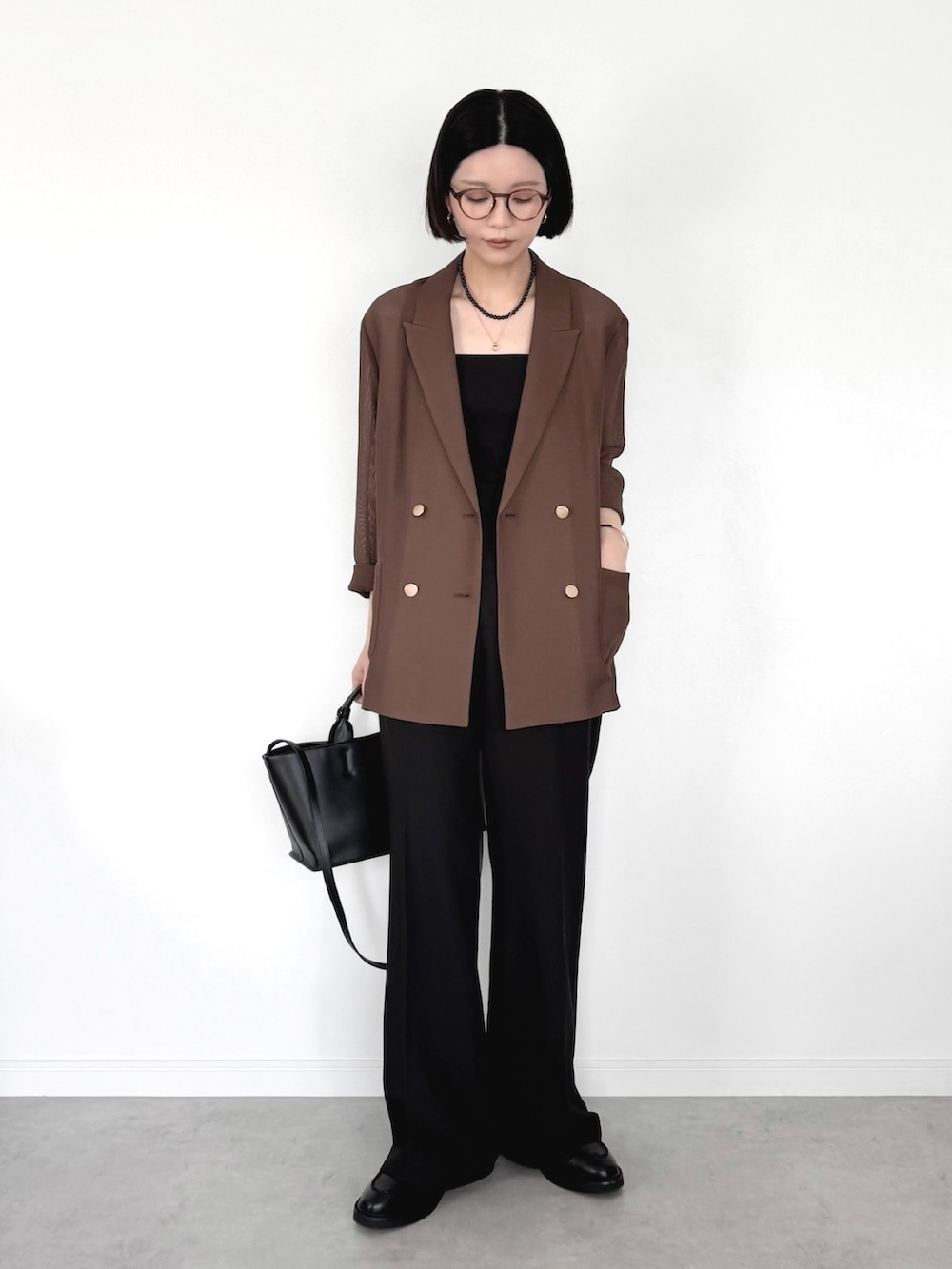 ブラウン系のテーラードジャケット、ブラック系のスラックス、ブラック系のトートバッグを着用したレディースの春コーディネートの2枚目の写真