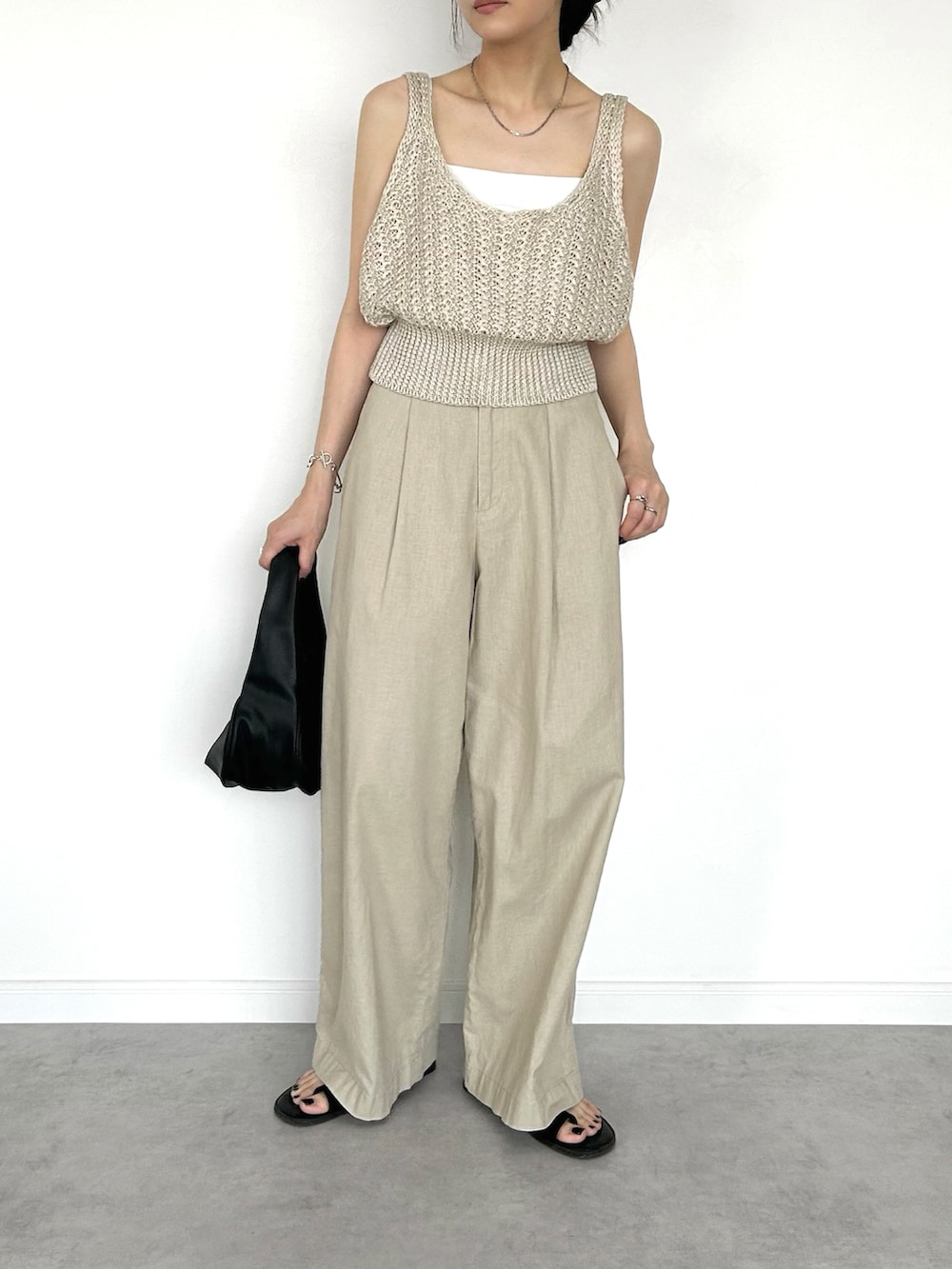 ホワイト系のベスト、ホワイト系のキャミソール、ベージュ系のパンツを着用したレディースの夏コーディネートの2枚目の写真