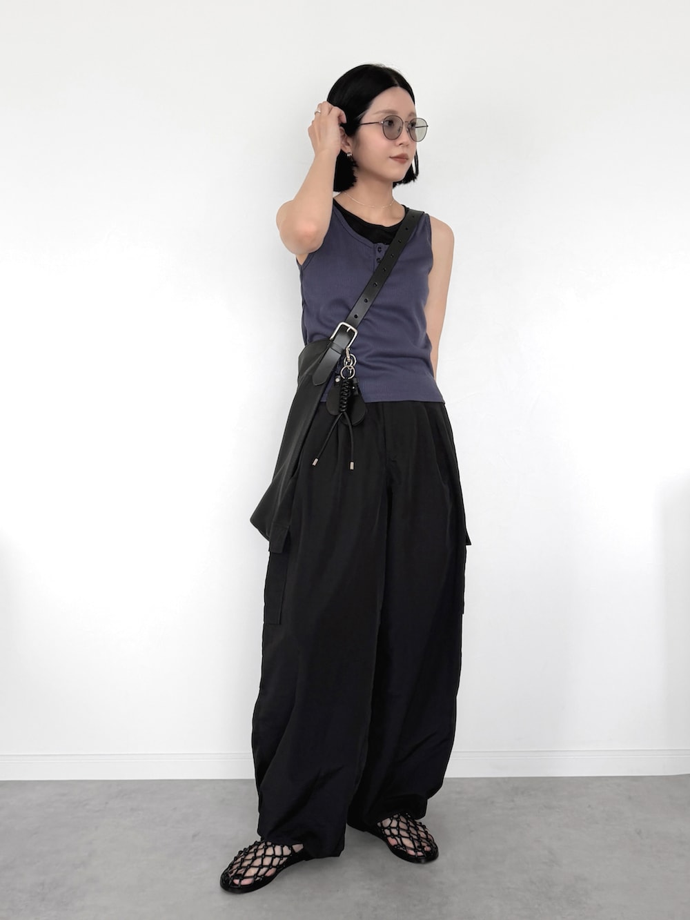 ブラック系のカーゴパンツ、ブルー系のタンクトップ、ブラック系のサンダルを着用したレディースの夏コーディネートの2枚目の写真