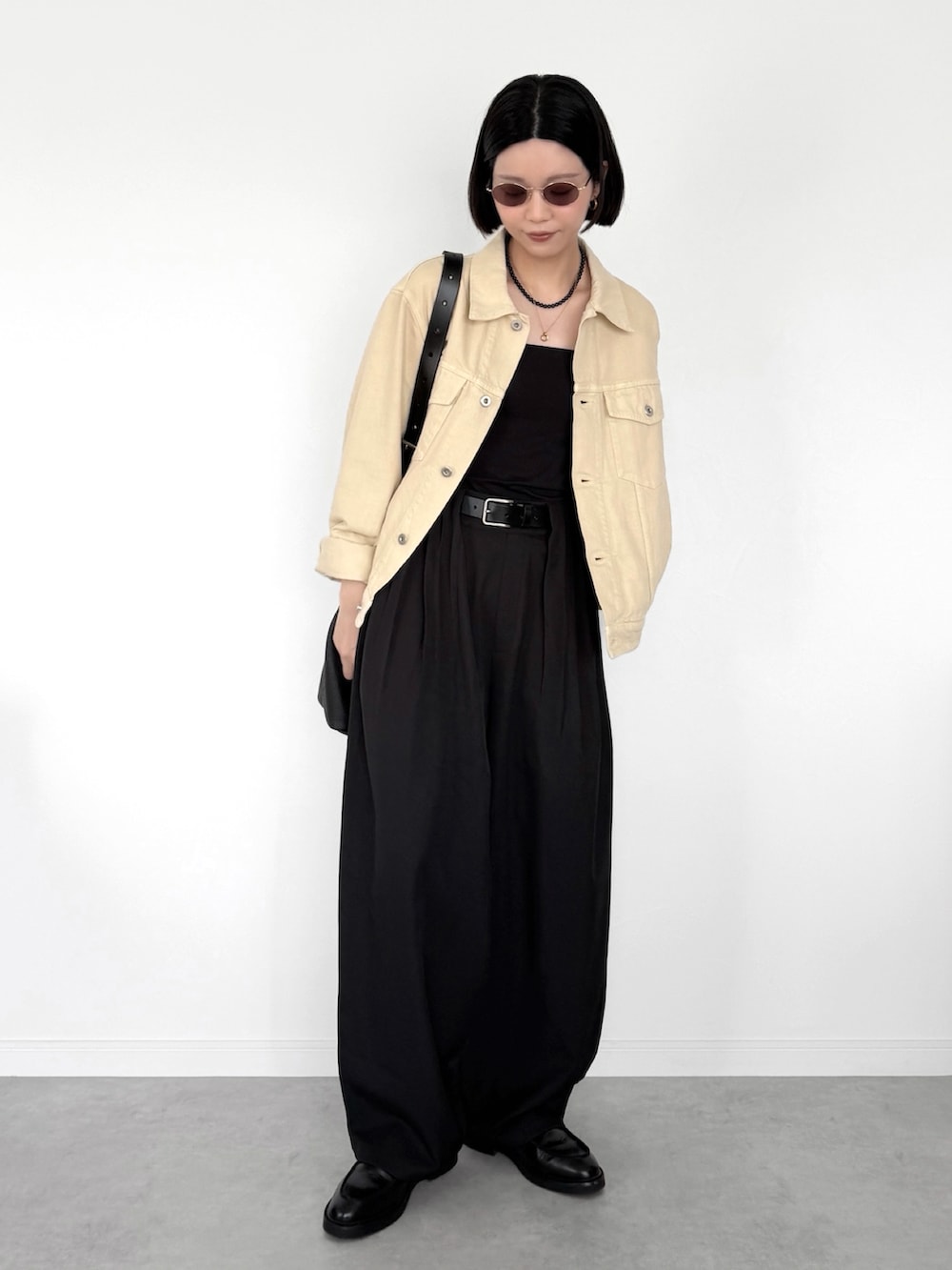 ブラック系のスラックス、イエロー系のジャケット/アウター、ブラック系のショルダーバッグを着用したレディースの春コーディネートの2枚目の写真