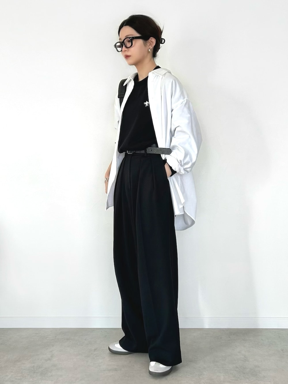 ブラック系のTシャツ/カットソー、ブラック系のその他パンツ、ホワイト系のスニーカーを着用したレディースの冬コーディネートの2枚目の写真