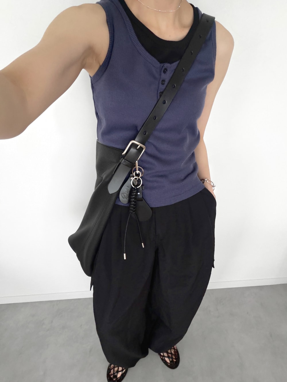 ブラック系のカーゴパンツ、ブルー系のタンクトップ、ブラック系のサンダルを着用したレディースの夏コーディネートの3枚目の写真