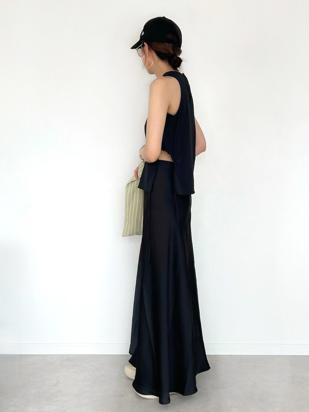 ブラック系のタンクトップ、ブラック系のスカート、イエロー系のエコバッグ/サブバッグを着用したレディースの夏コーディネートの2枚目の写真