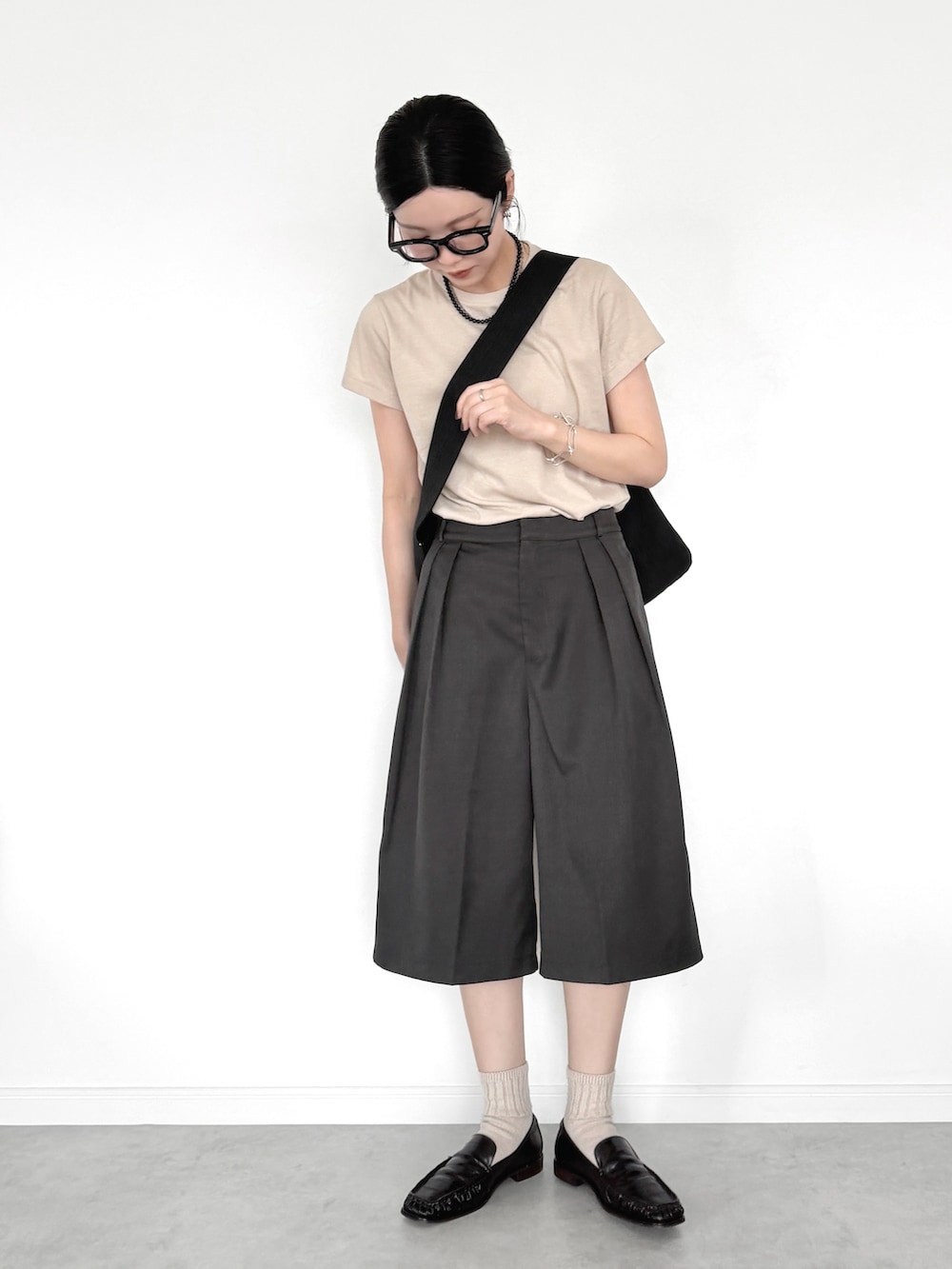 ブラック系のその他パンツ、ブラック系のショルダーバッグ、ブラウン系のローファーを着用したレディースの夏コーディネートの2枚目の写真