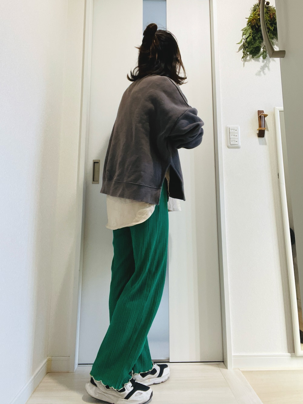 グレー系のスウェット、グリーン系のその他パンツ、ホワイト系のスニーカーを着用したレディースの冬コーディネートの2枚目の写真