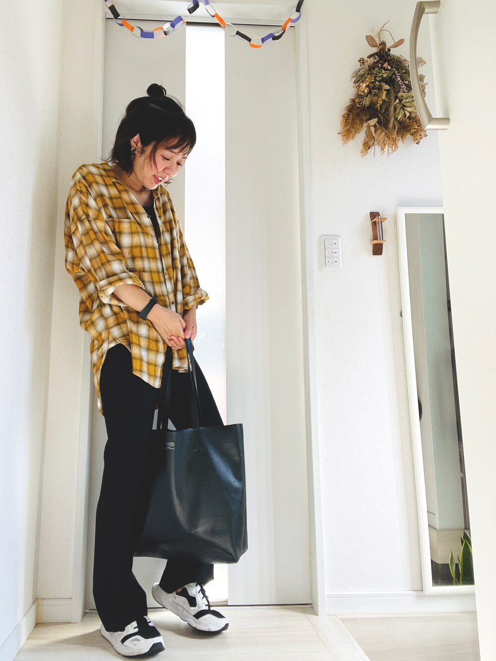 イエロー系のシャツ/ブラウス、ブラック系のスラックス、ホワイト系のスニーカーを着用したレディースの秋コーディネートの2枚目の写真