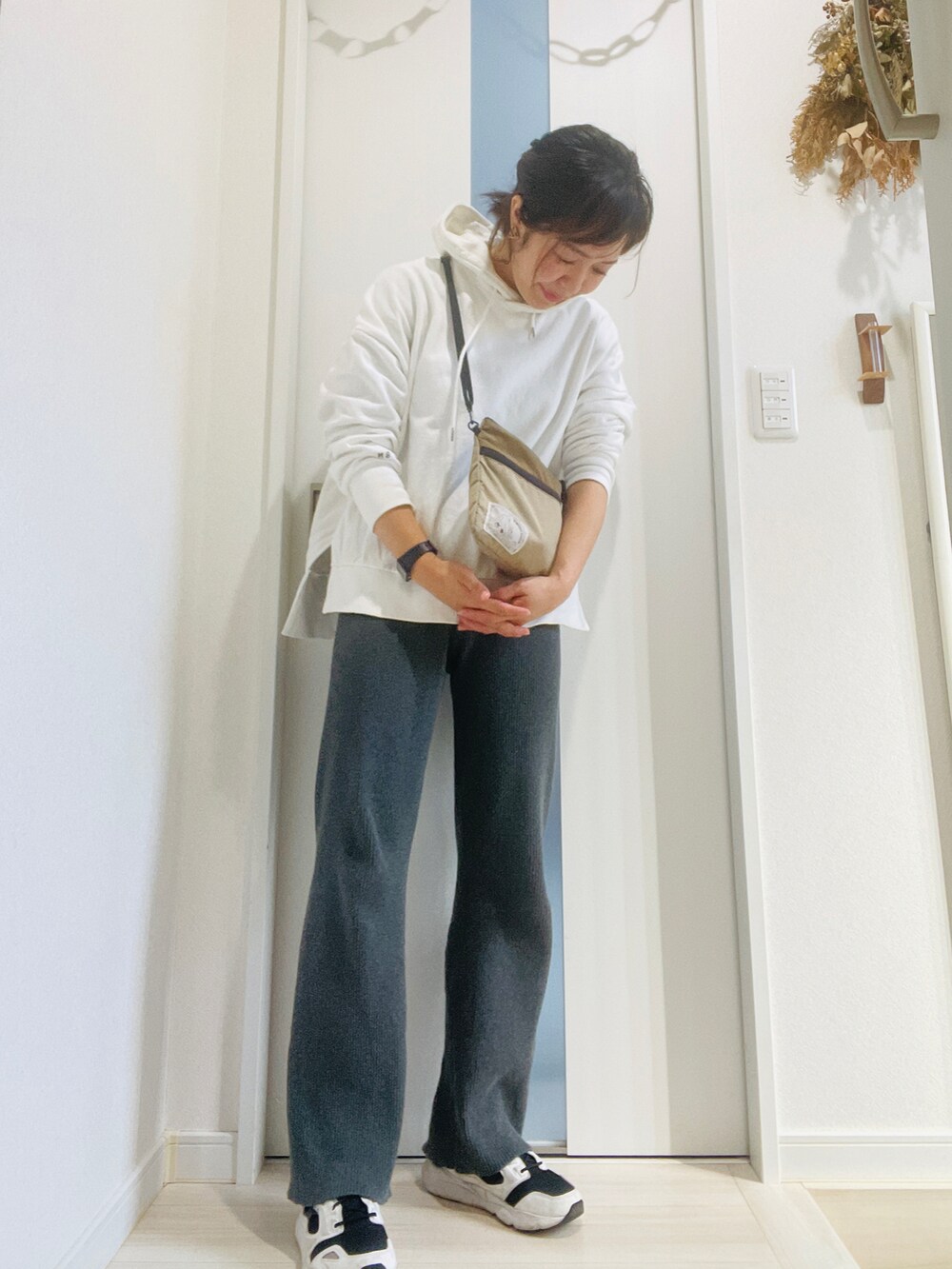 ホワイト系のパーカー、グレー系のその他パンツ、ホワイト系のスニーカーを着用したレディースの秋コーディネートの3枚目の写真