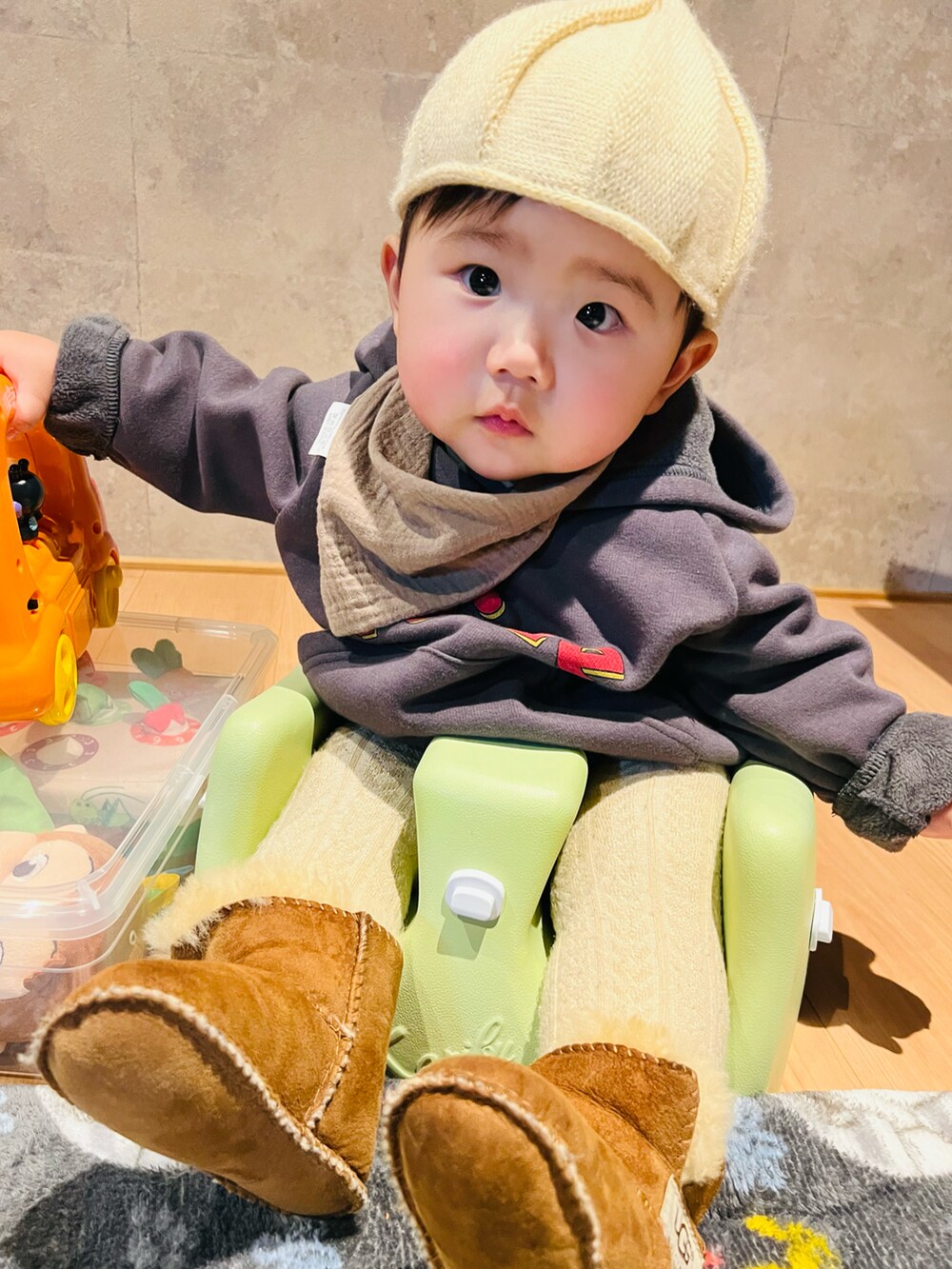 ベージュ系の帽子、ブラウン系のスタイ/よだれかけ、グレー系のその他ベビーウェアを着用したキッズの冬コーディネートの4枚目の写真