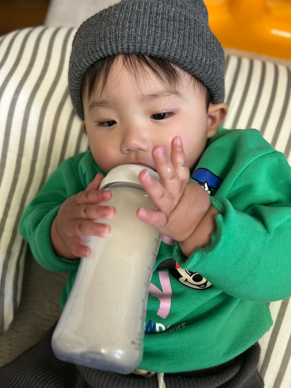 グリーン系のスウェット、グレー系のパンツ、ブラック系のニットキャップ/ビーニーを着用したキッズの冬コーディネートの2枚目の写真