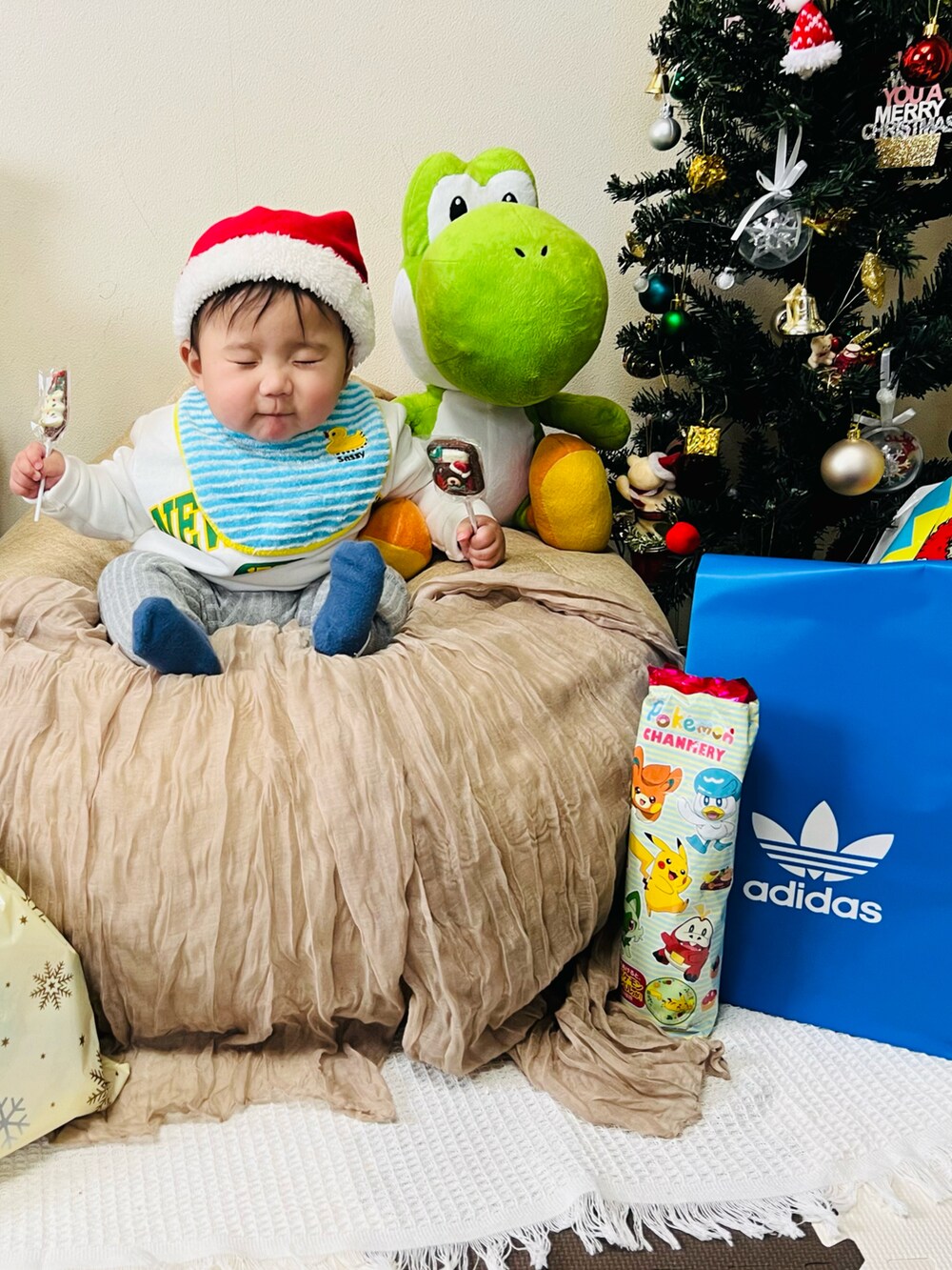 ホワイト系のスウェット、ホワイト系のベビーシューズ/ベビーソックス、ブルー系のスタイ/よだれかけを着用したキッズの冬コーディネートの2枚目の写真