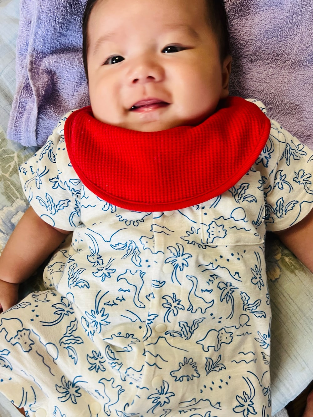 ホワイト系のロンパース、レッド系のスタイ/よだれかけを着用したキッズの冬コーディネートの2枚目の写真